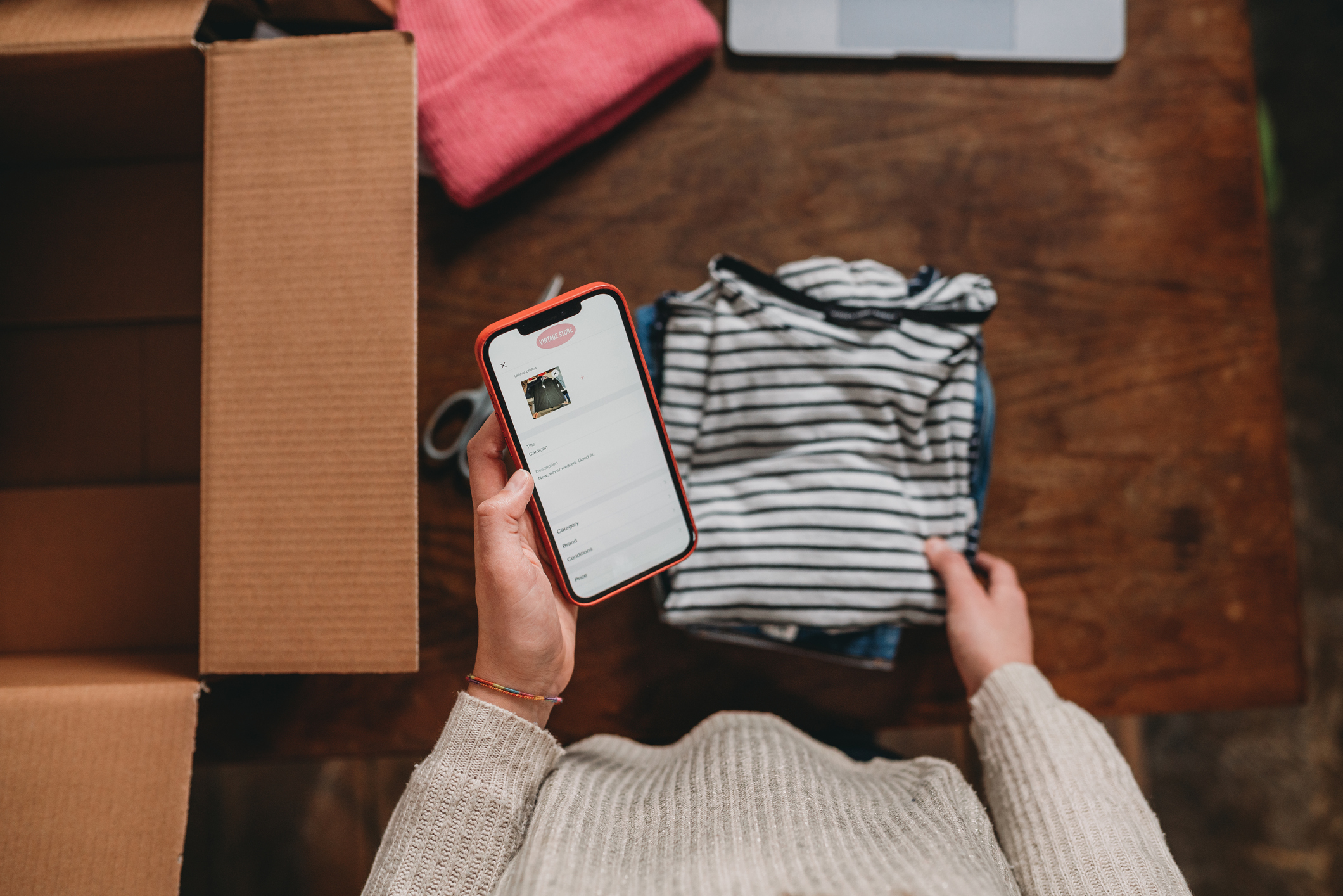 Man on clothes selling app next toempty cardboard box