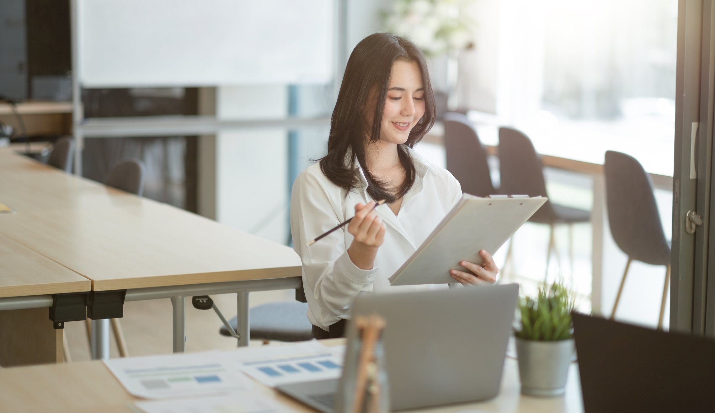 person looking at business sheet while on laptop