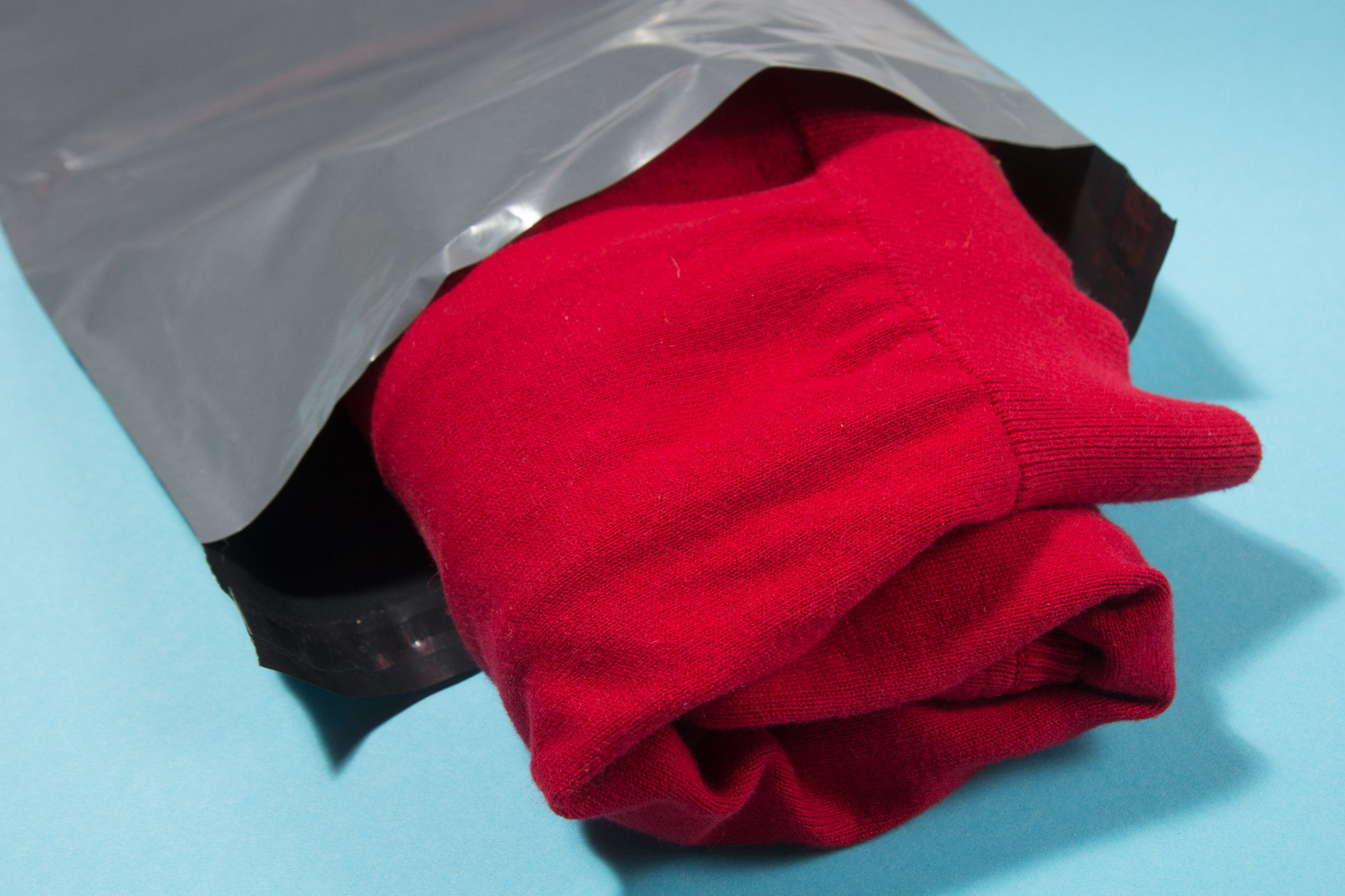 Red jumper in a silver poly mailer bag
