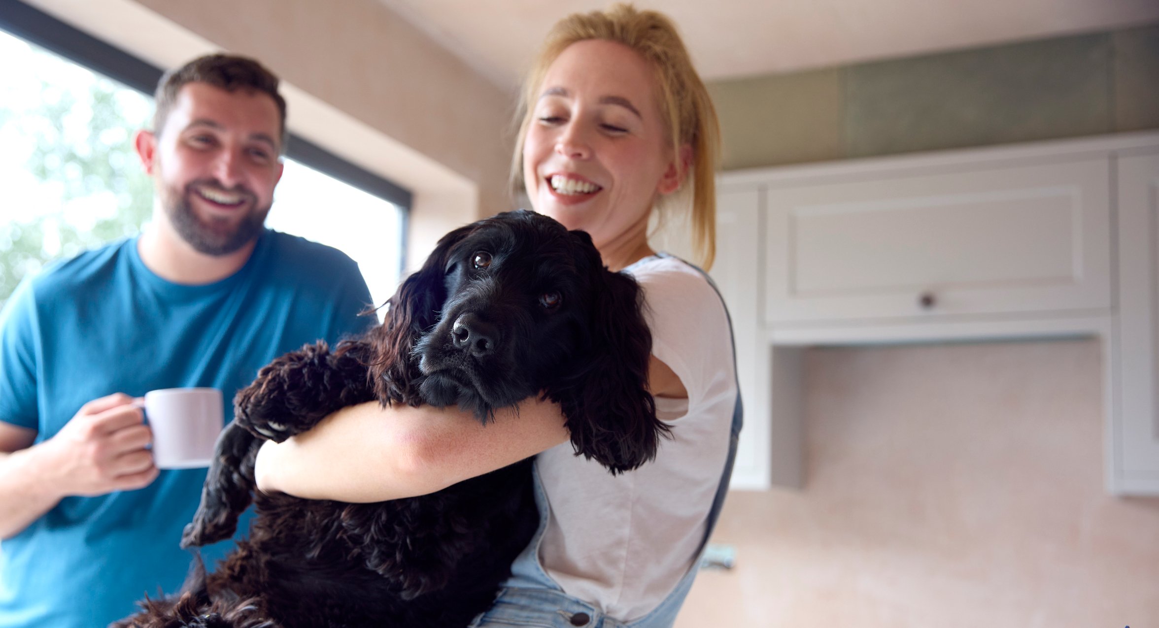 Couple with spaniel dog in their arms
