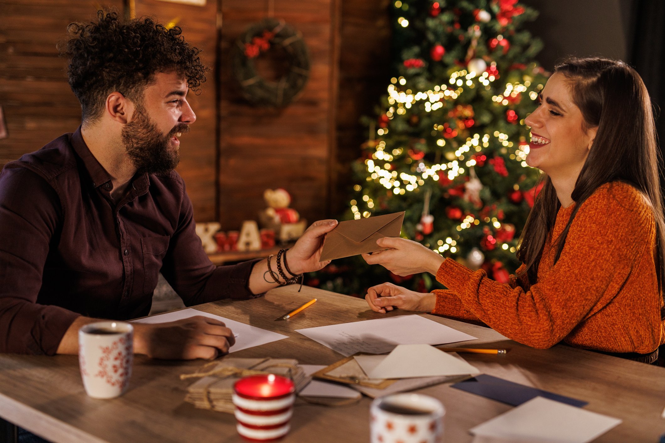 couple-smiling-and-sealing-christmas-card