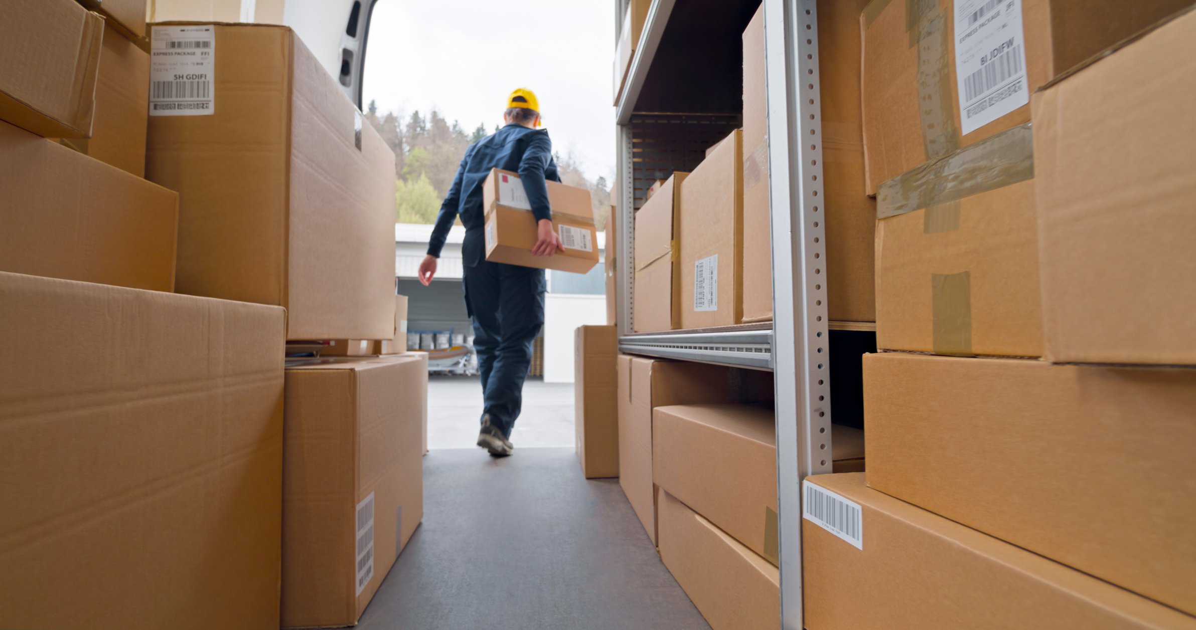 delivery person carrying parcels from van