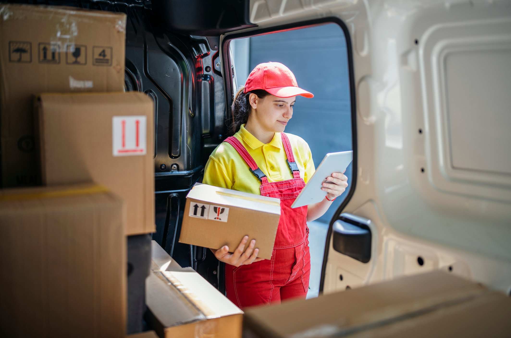 delivery person holding parcel while looking at sheet