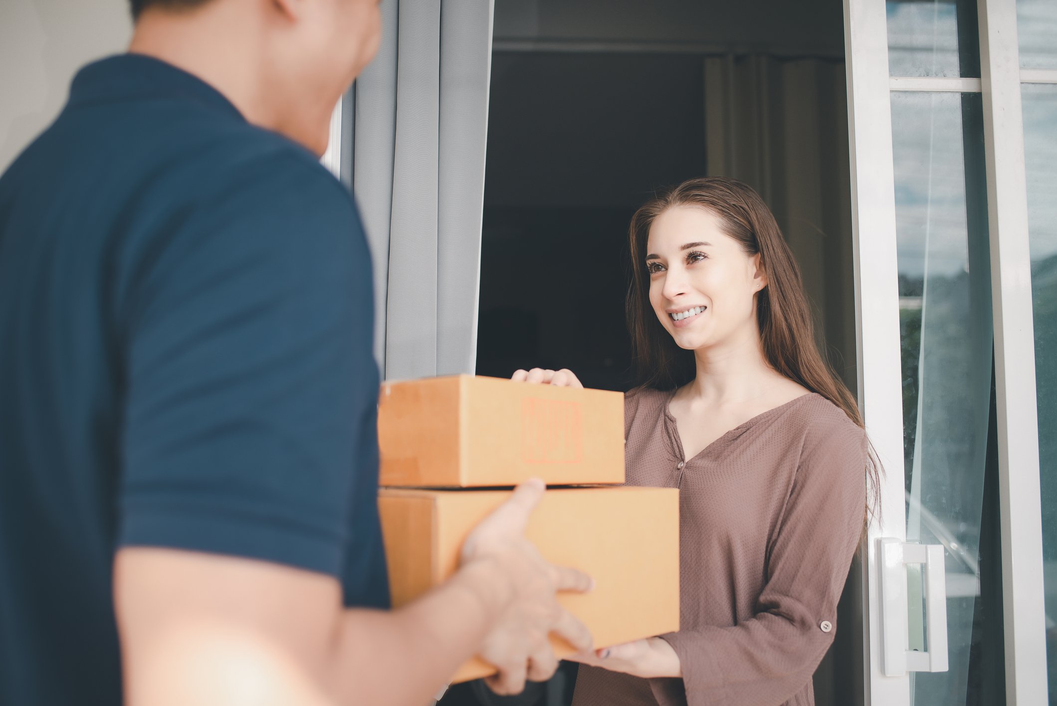delivery man handing parcel to woman