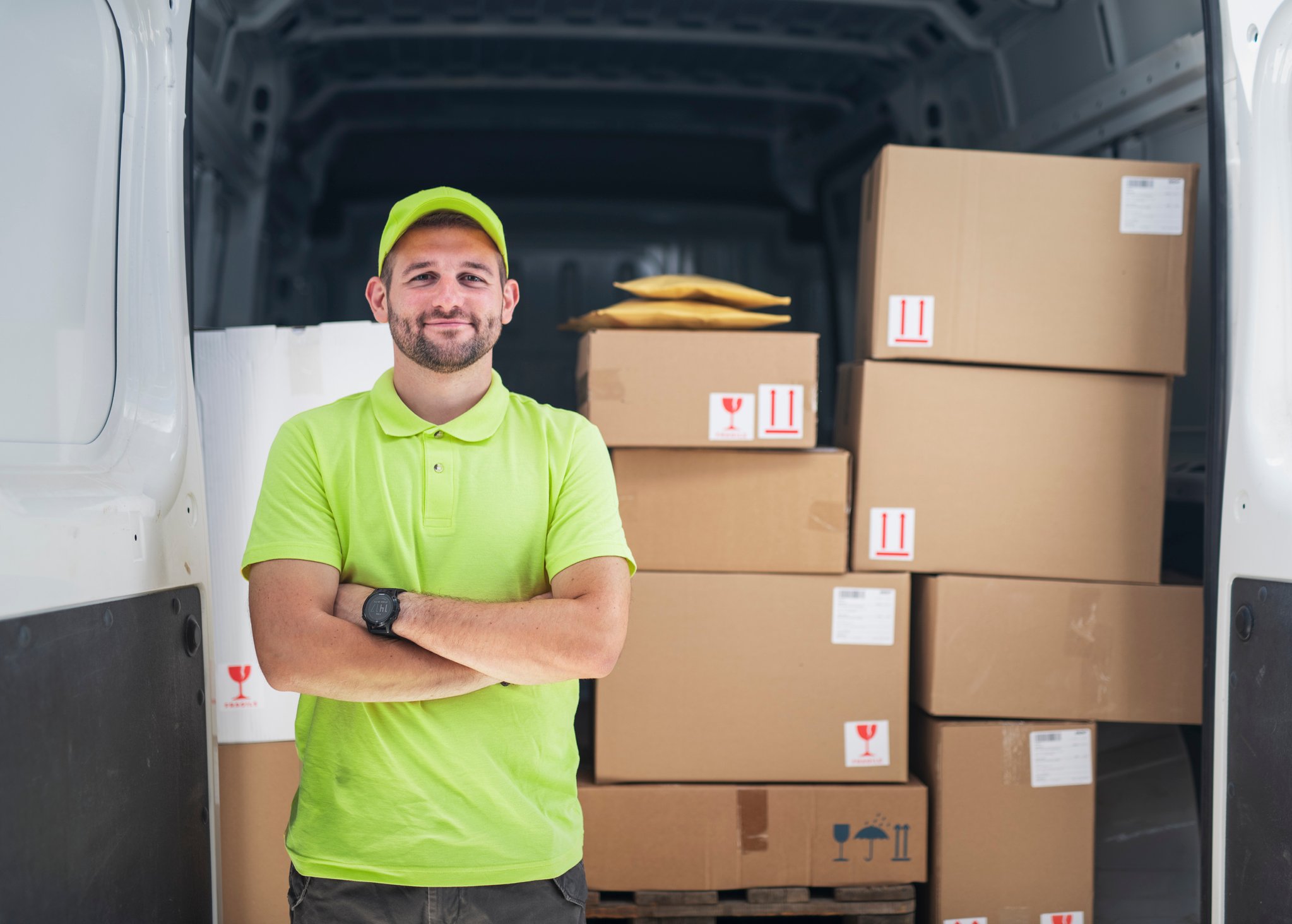 Smiling delivery driver in front of van