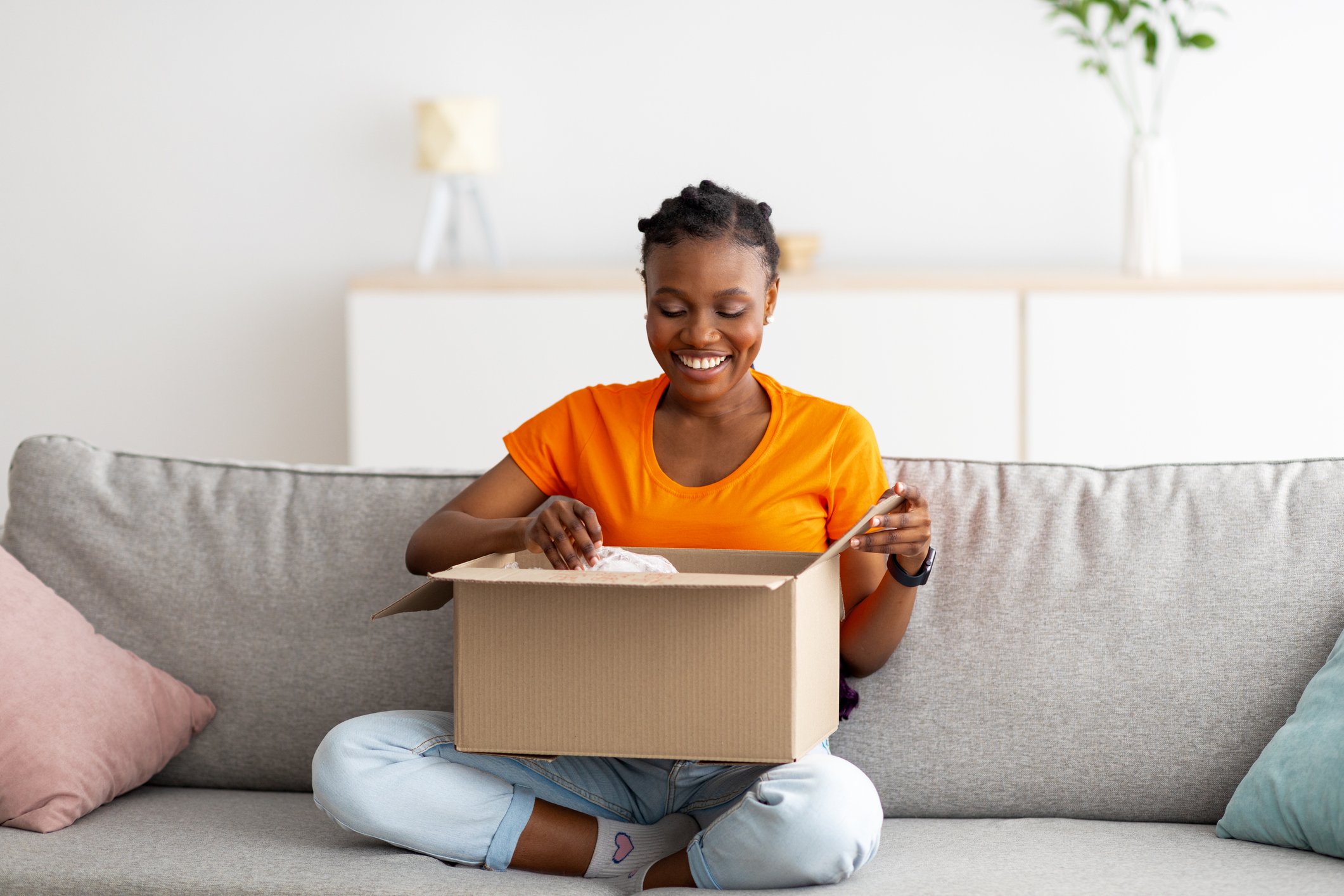 Smiling woman opening parcel