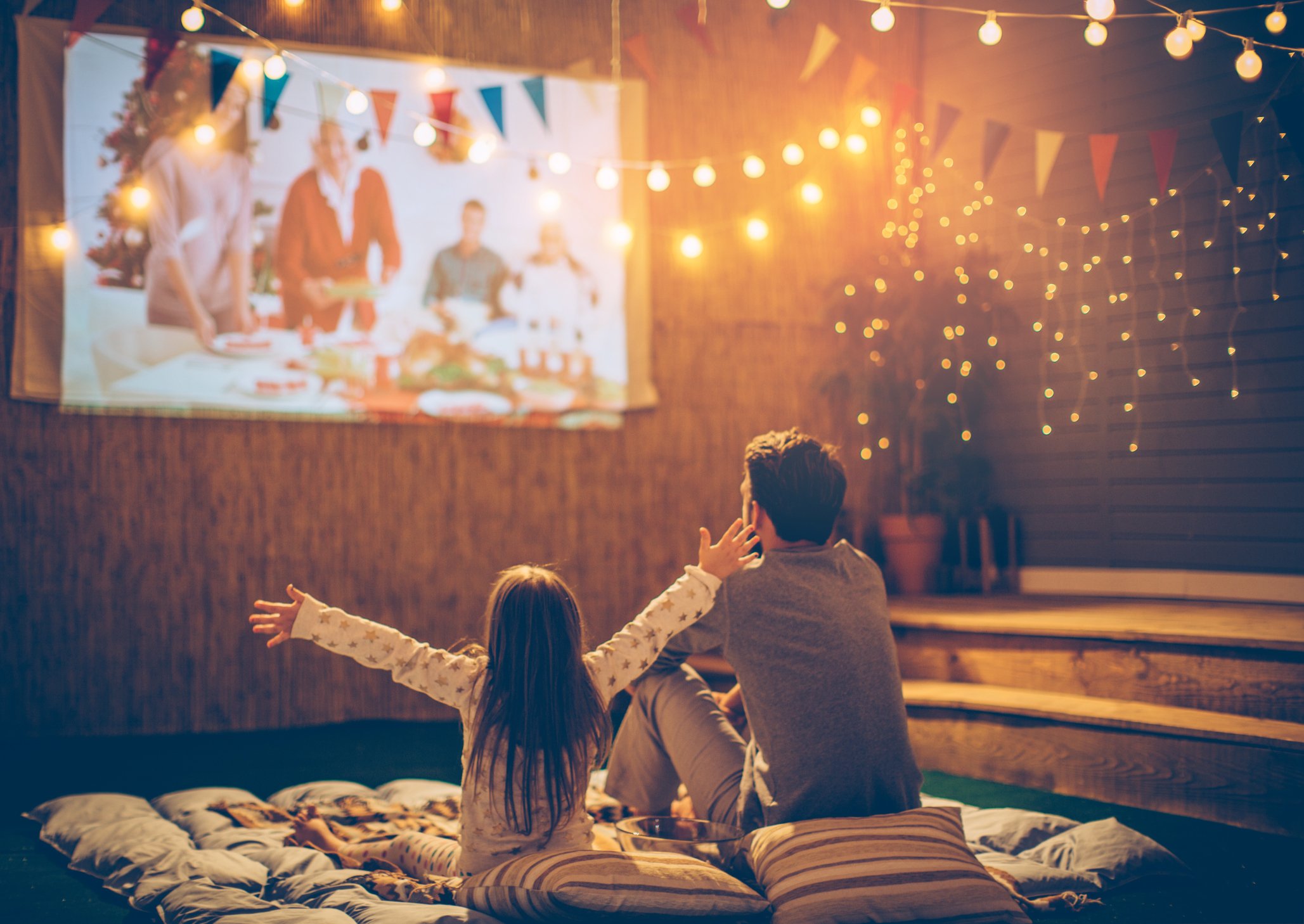 Man and child watching projector in garden