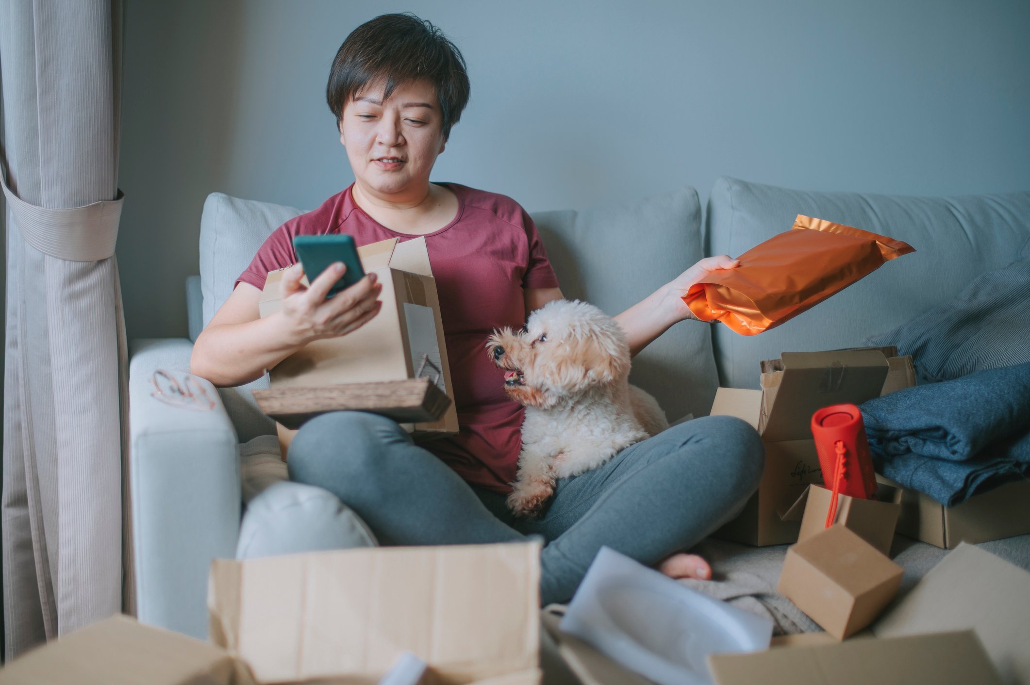 Lady with fluffy dog and boxes on phone