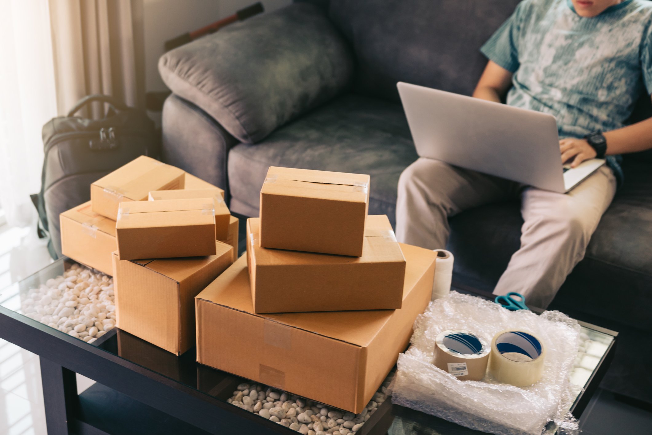 man on laptop next to parcels