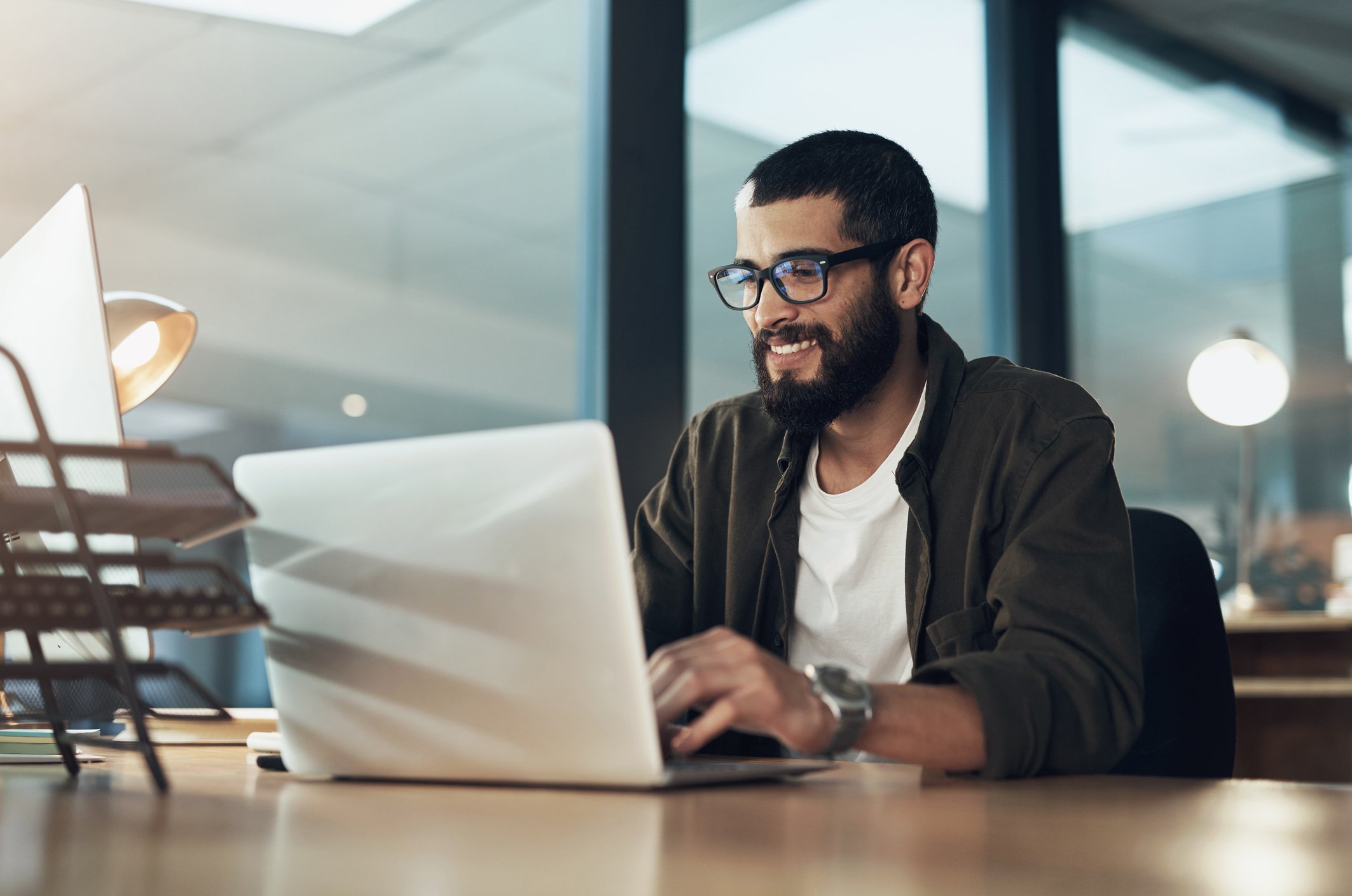 man smiling while using laptop