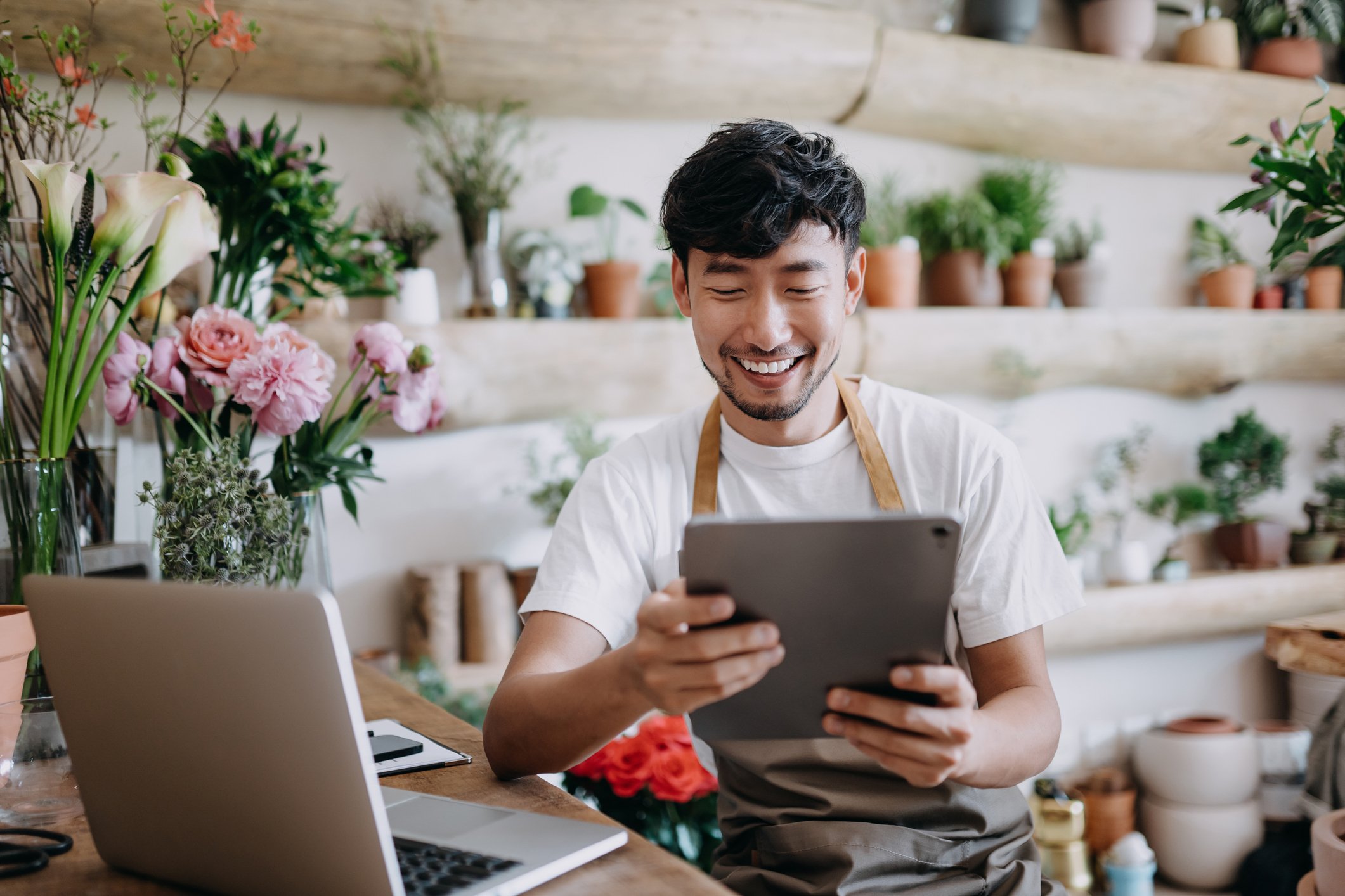 man using tablet in flower store