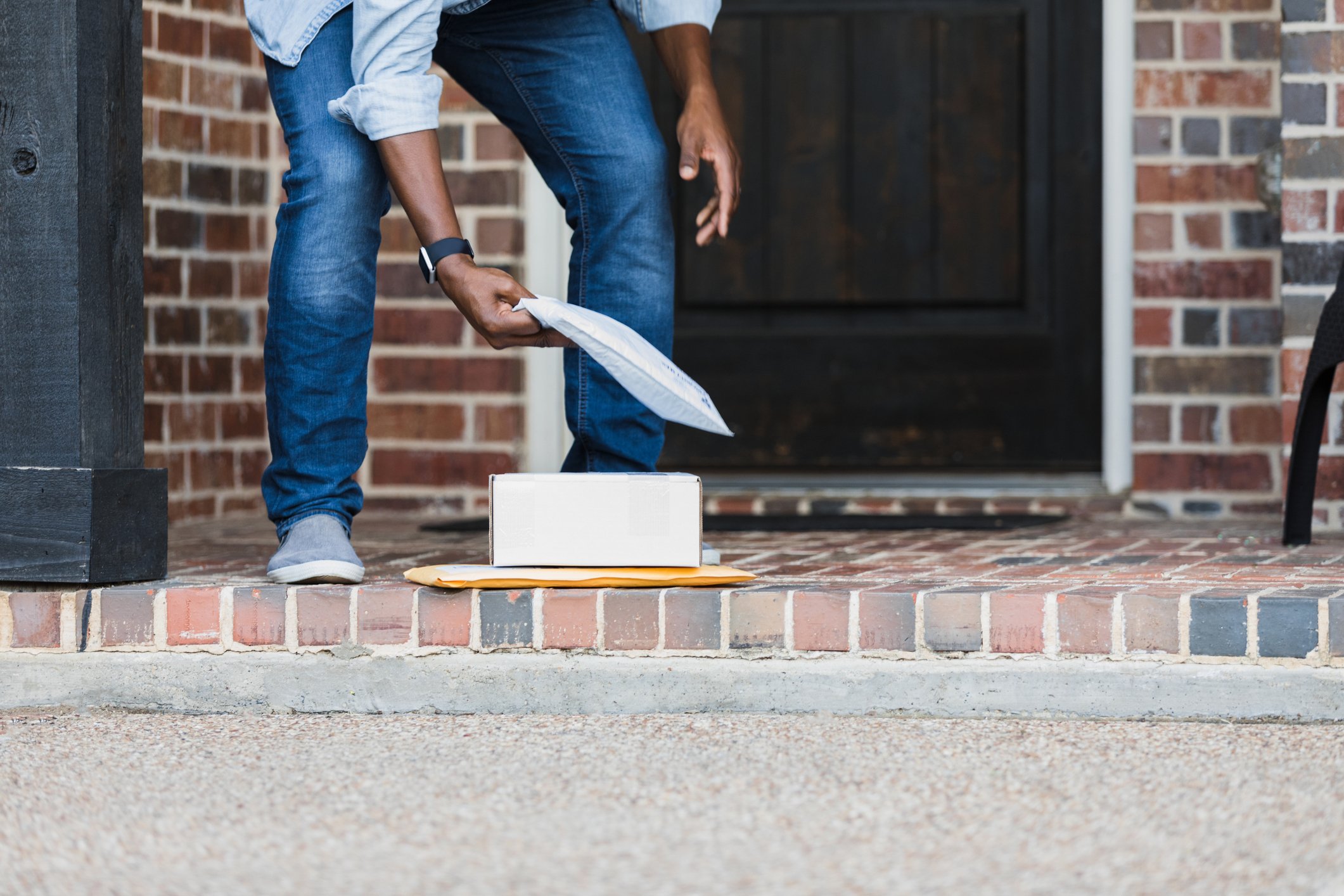 Man collecting parcel at front door