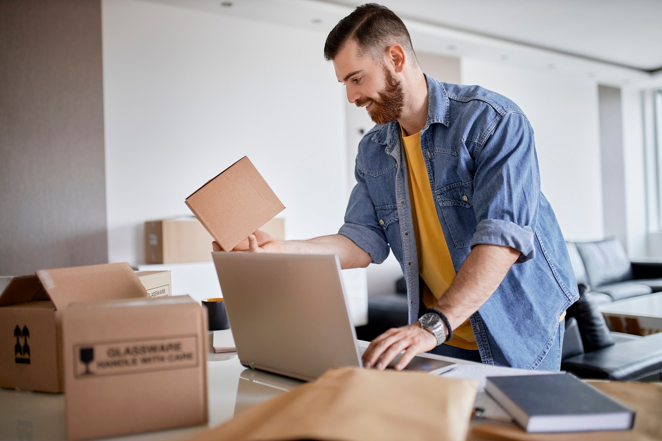 person holding parcel while using laptop