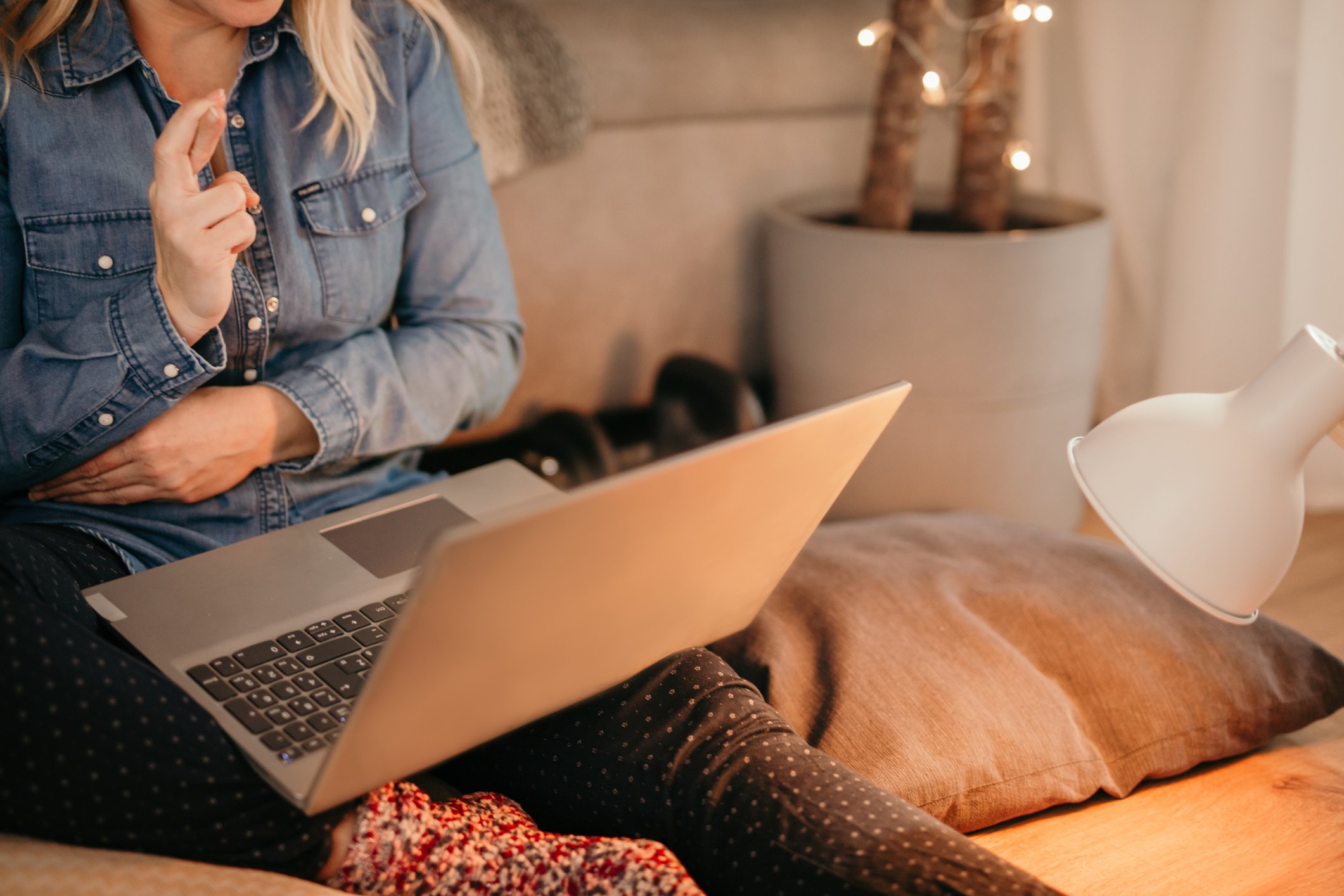 Woman sat at laptop with fingers crossed