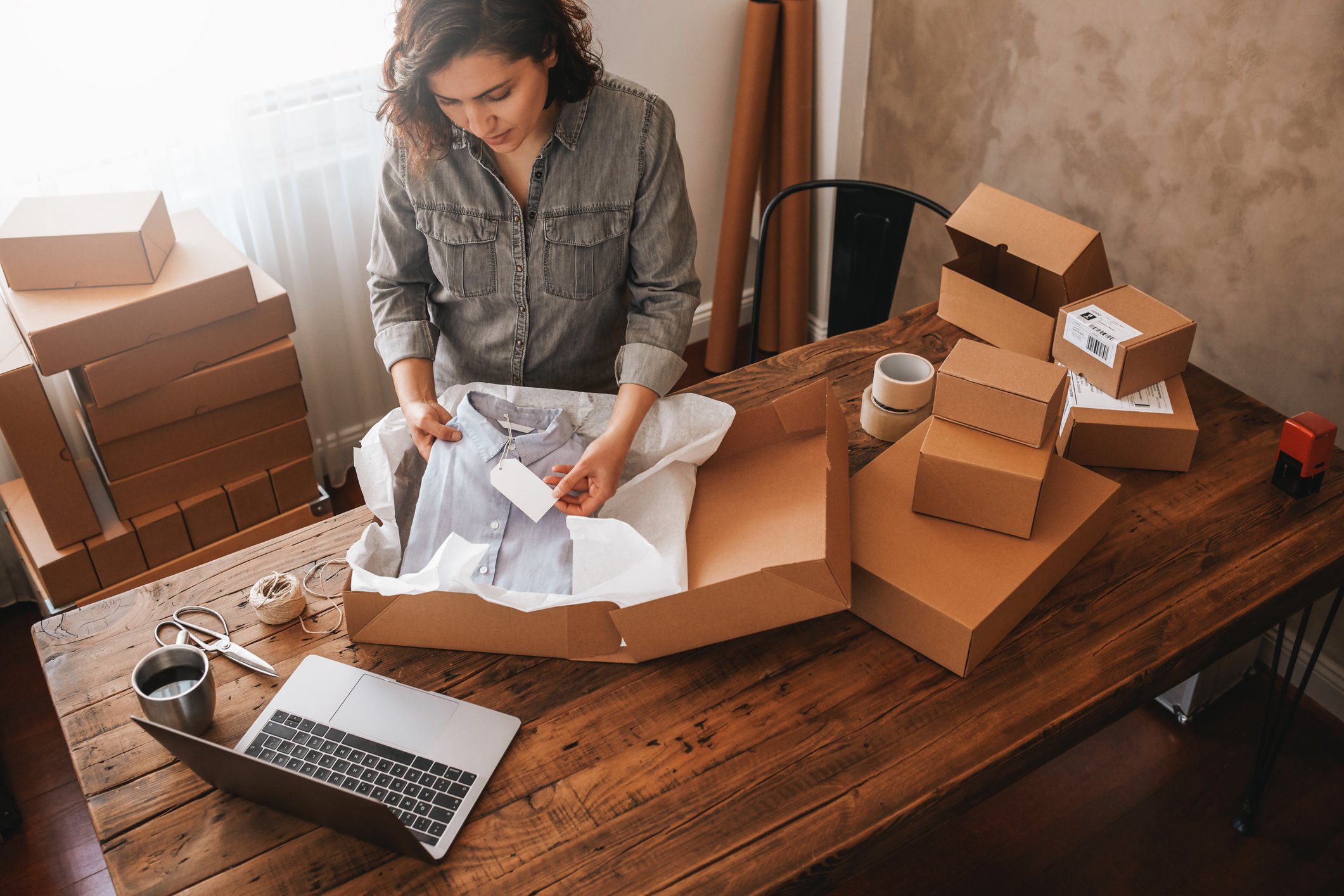 person packing clothes into a parcel