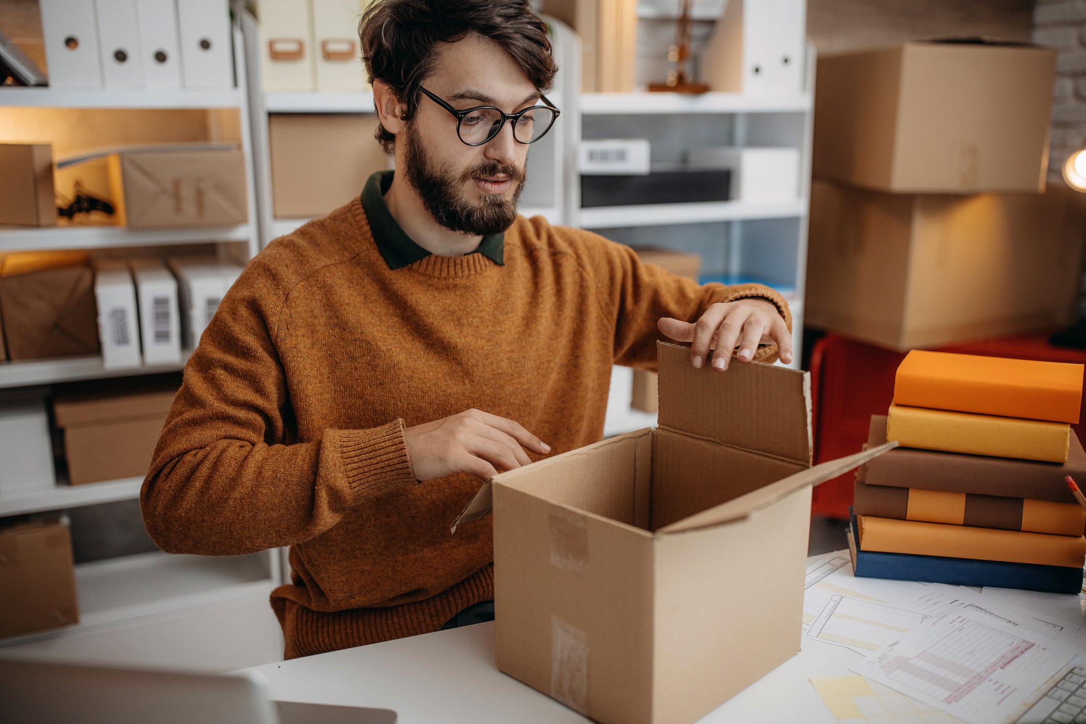 person packing books into parcel