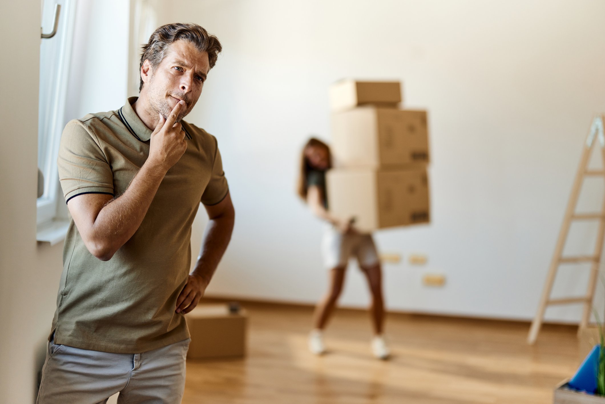 person looking confused with someone else carrying parcels in background