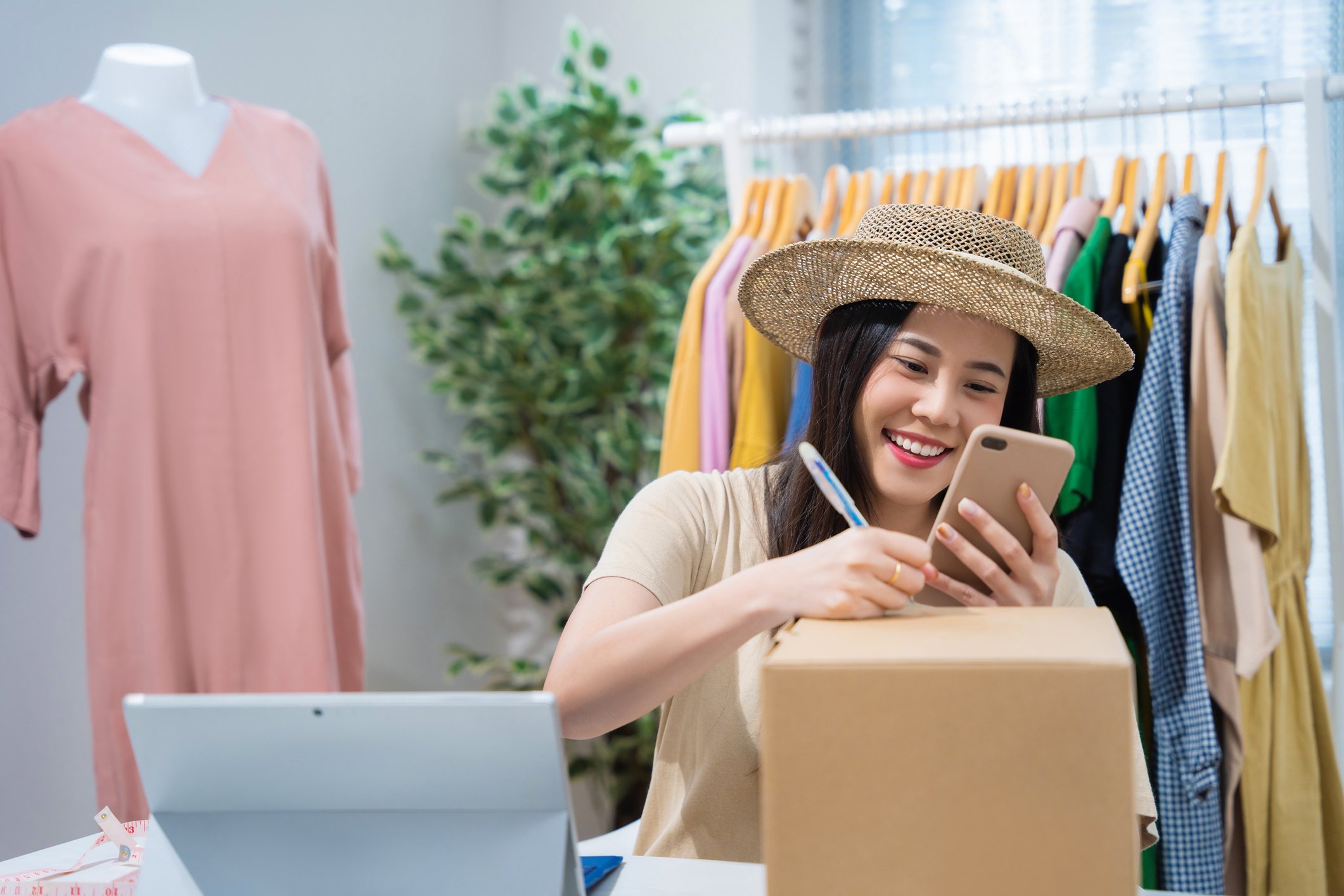 person packing a box with clothes in background