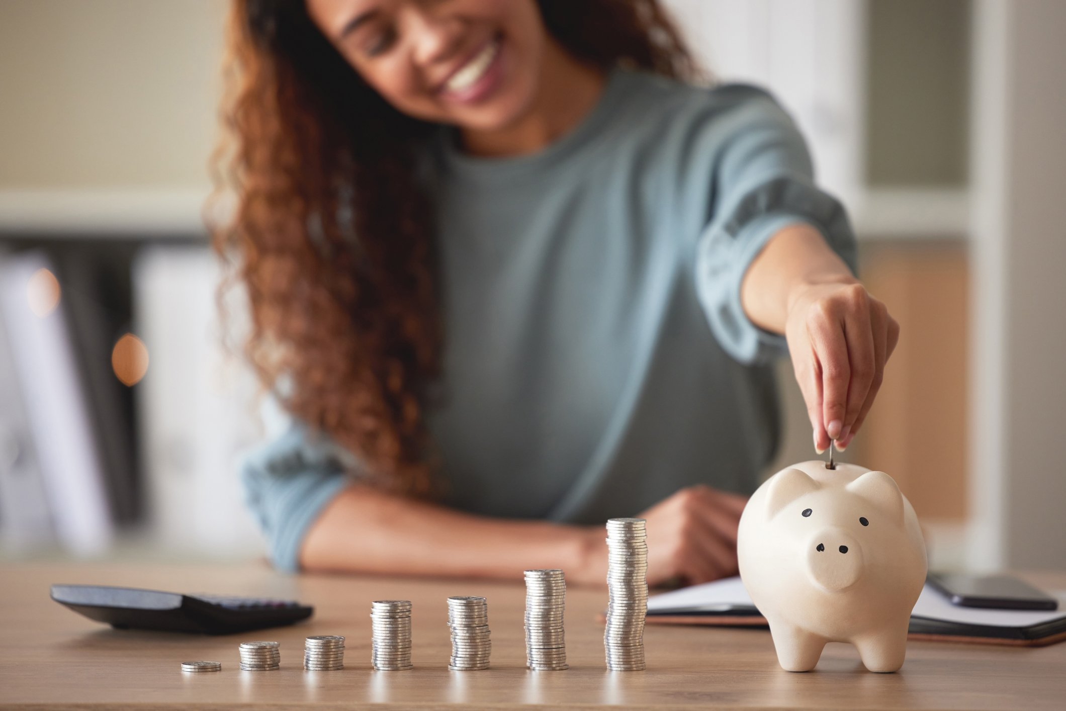 person putting coins into piggy bank