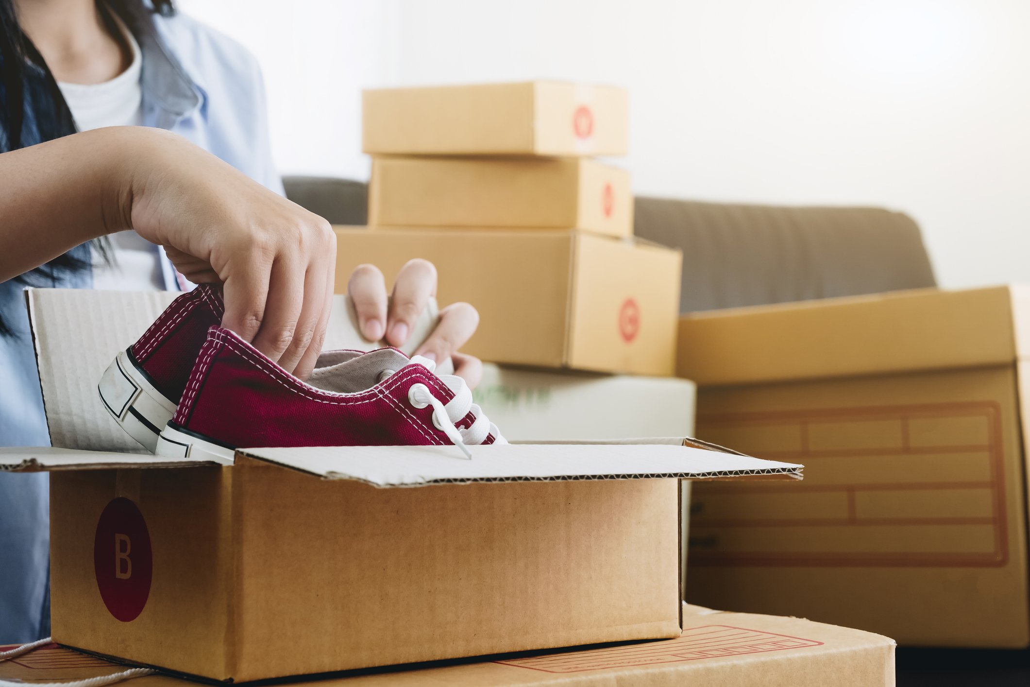 person putting shoes into parcel