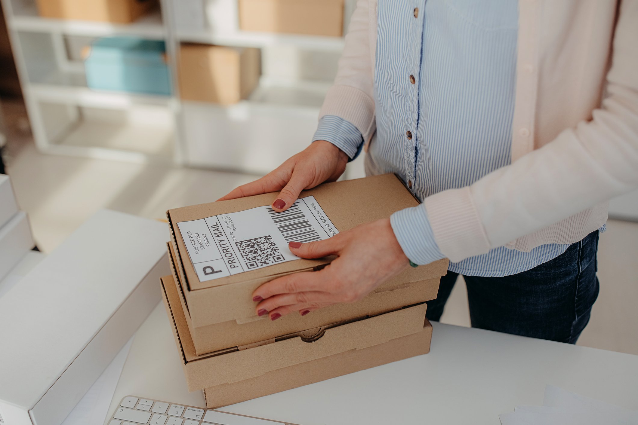 person sticking shipping label onto parcel