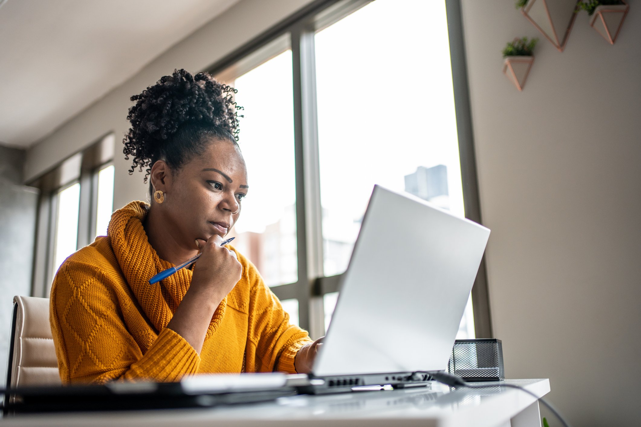 woman using laptop and thinking