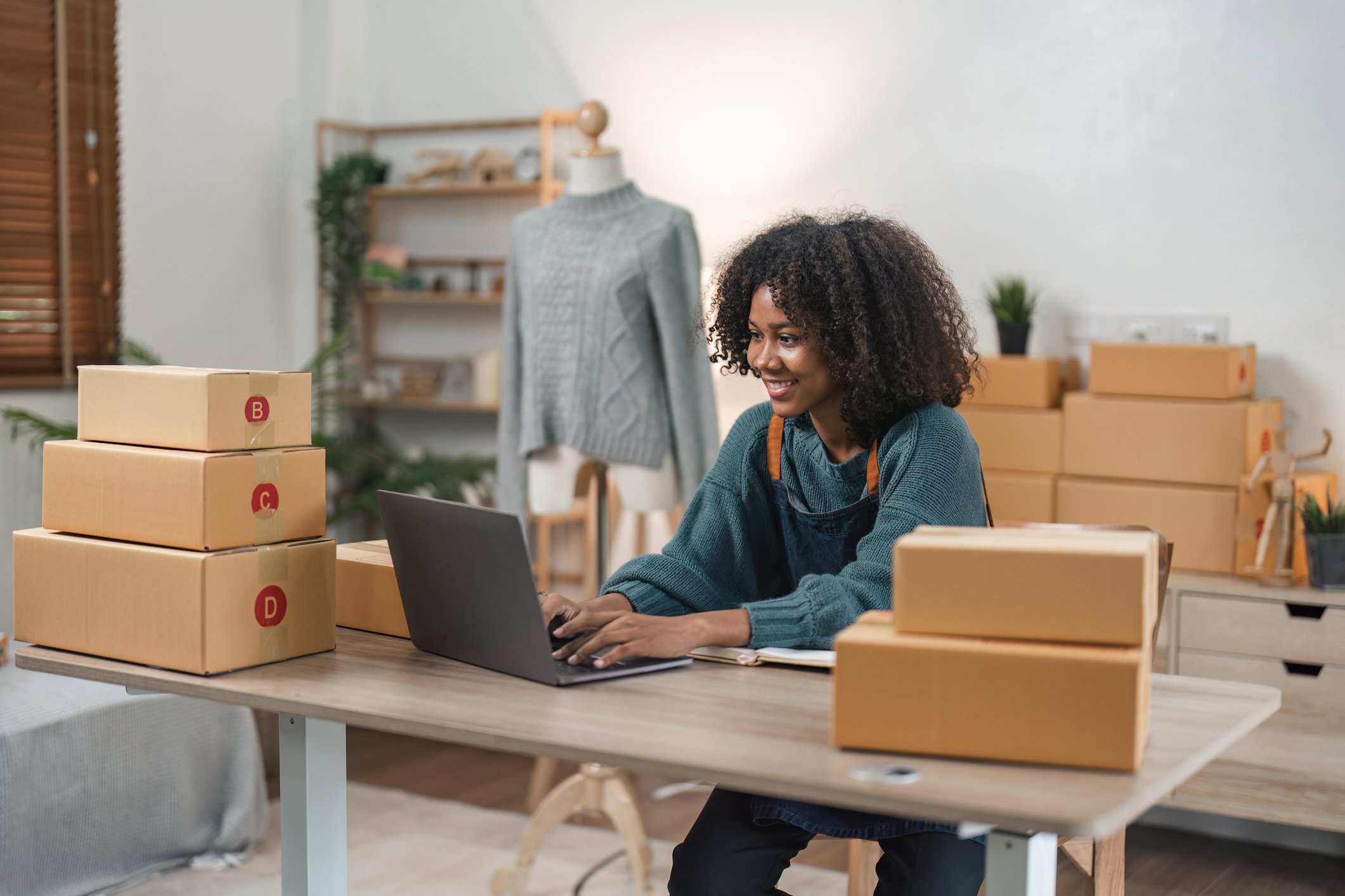 person using laptop with parcels around them