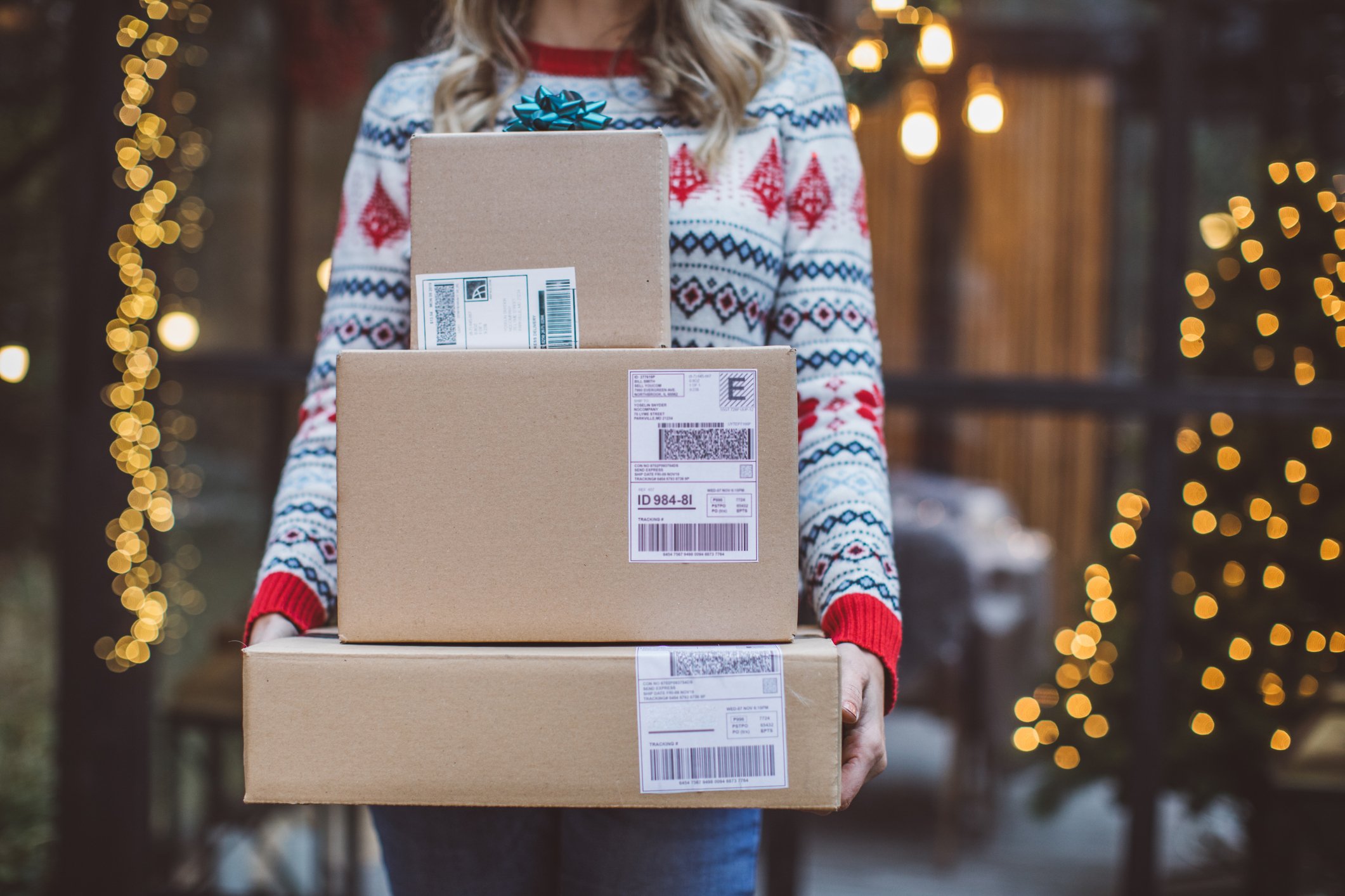 person-in-christmas-jumper-holding-parcels