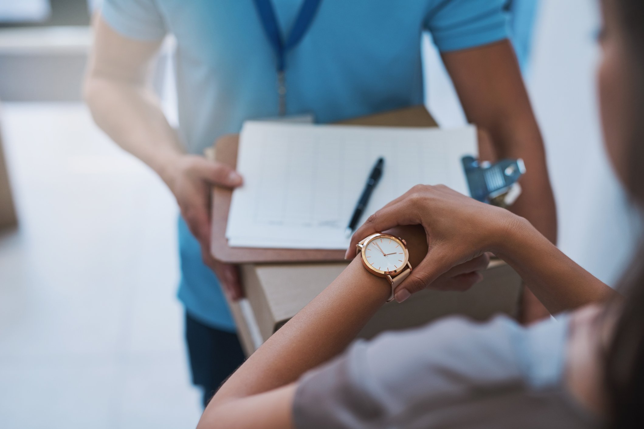 person looking at watch while signing for parcel