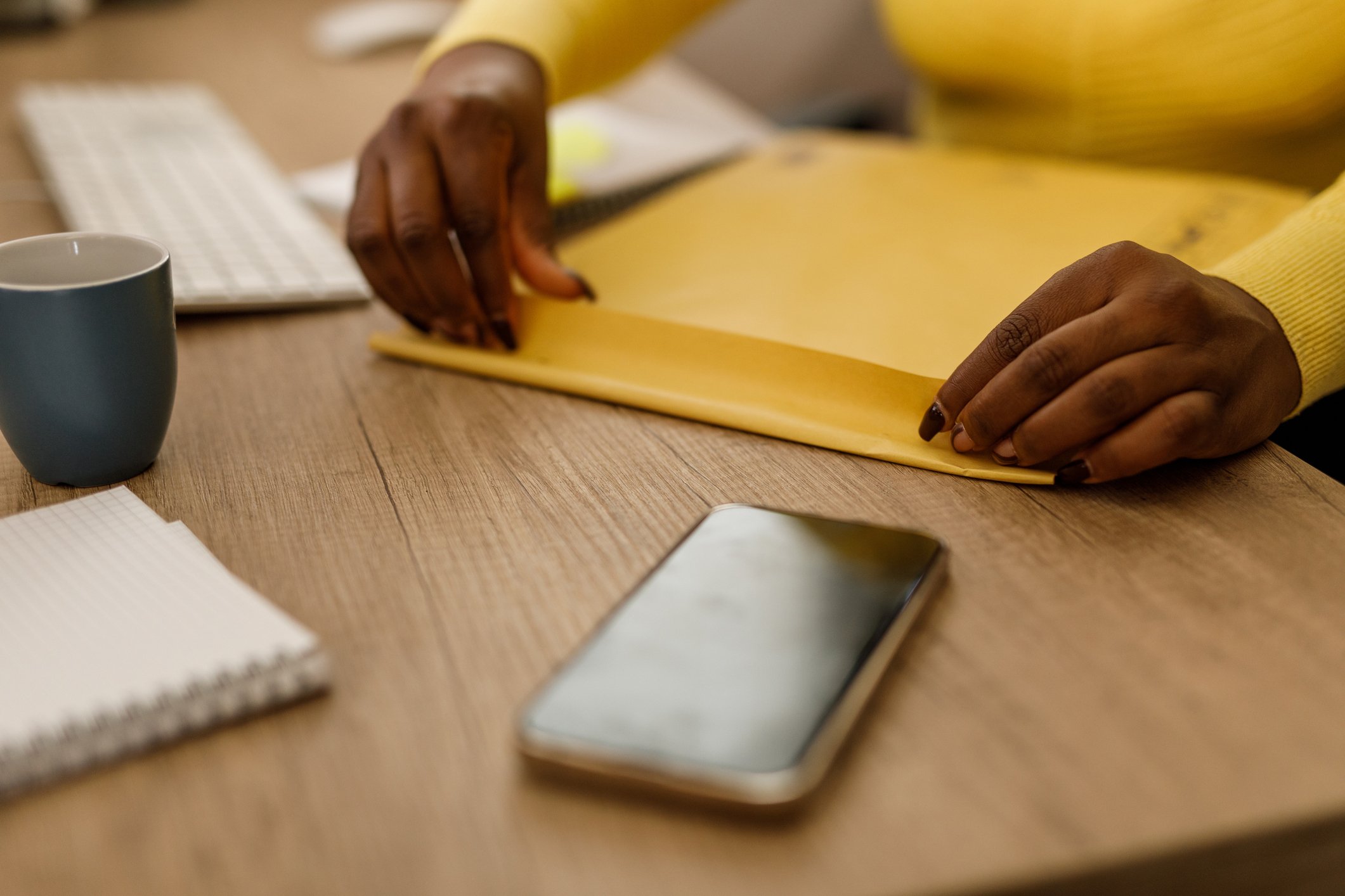 person-sealing-letter-envelope