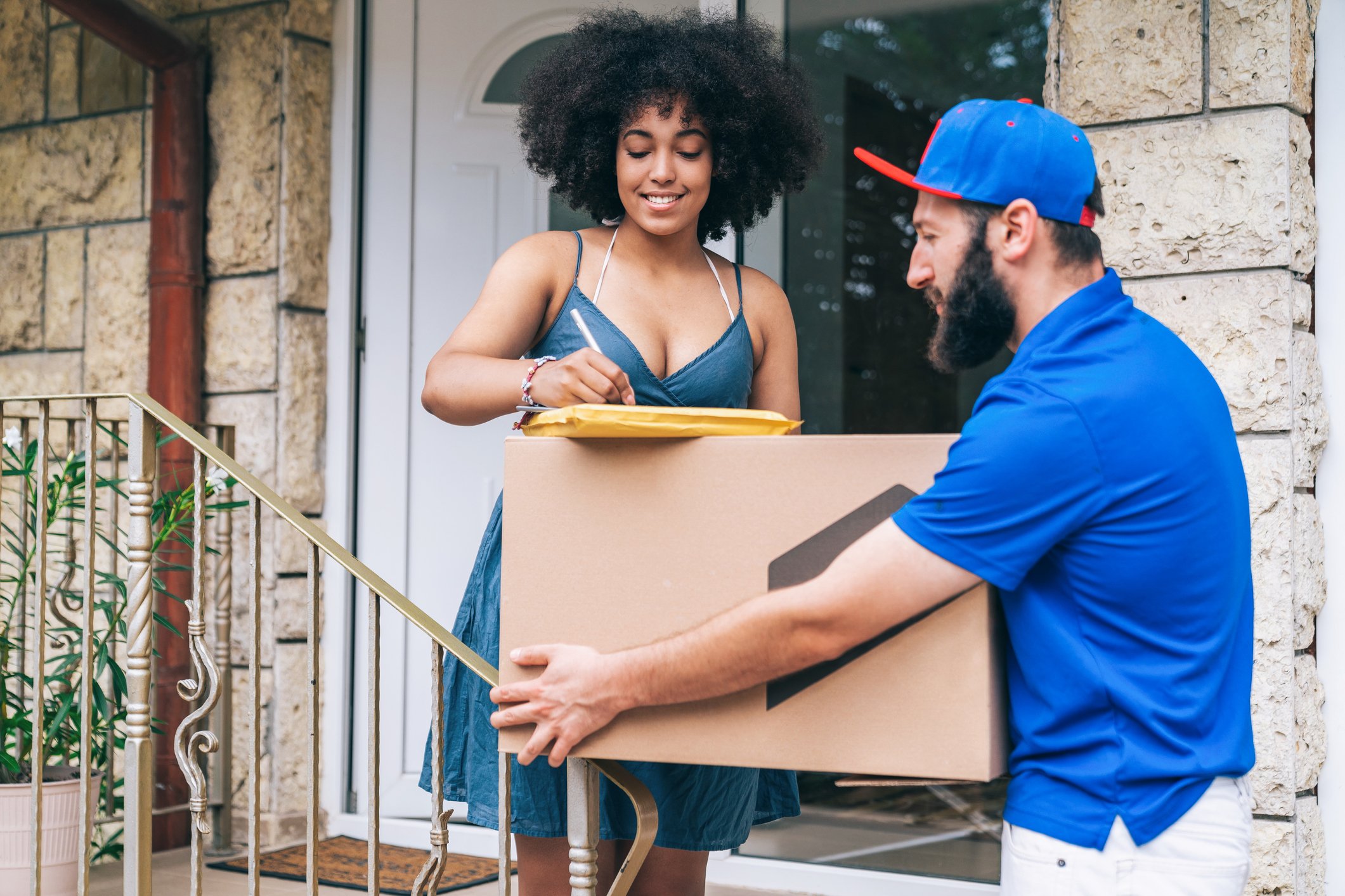 Smiling woman signing for a parcel