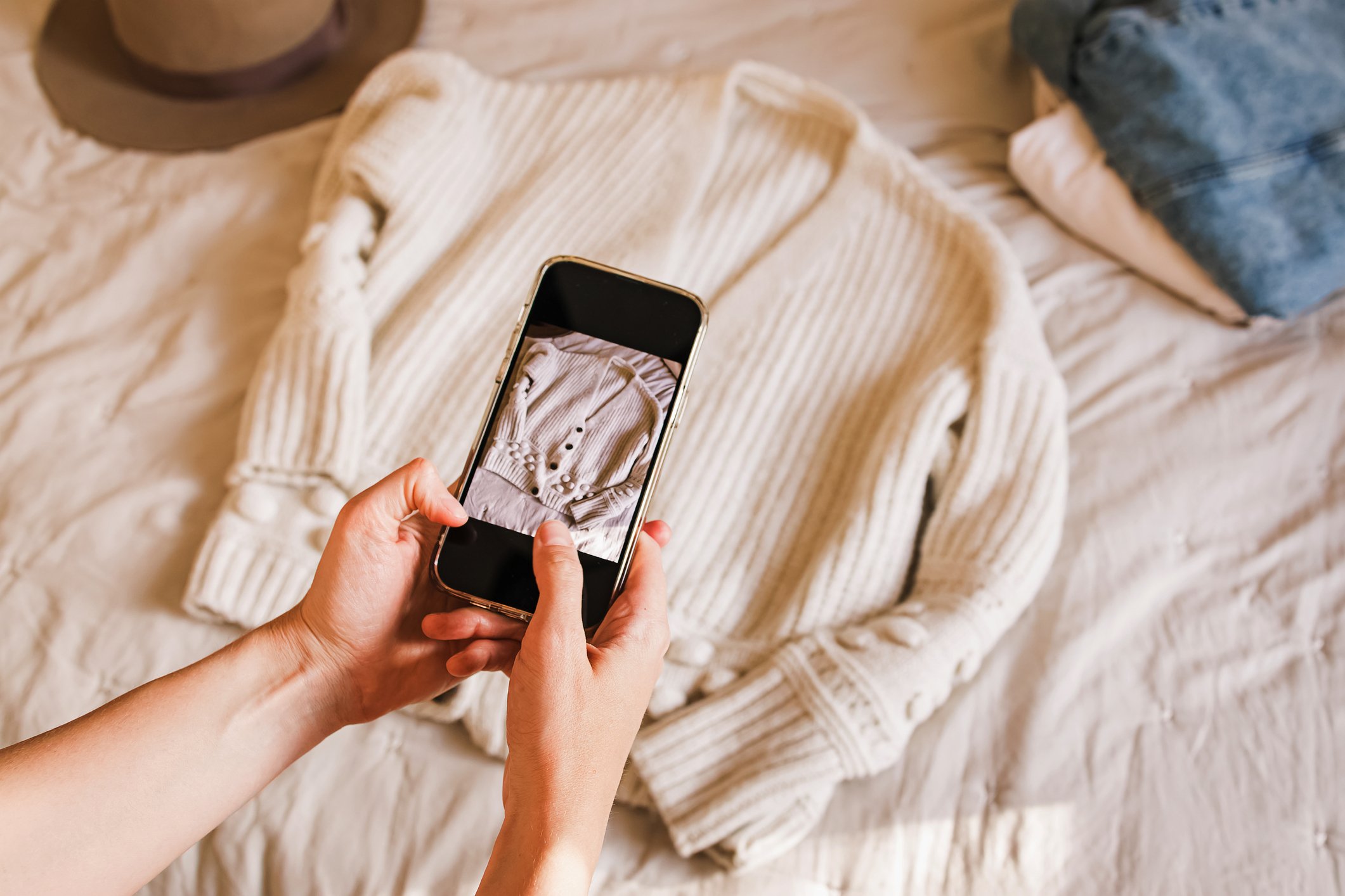 person taking photo of sweater to sell