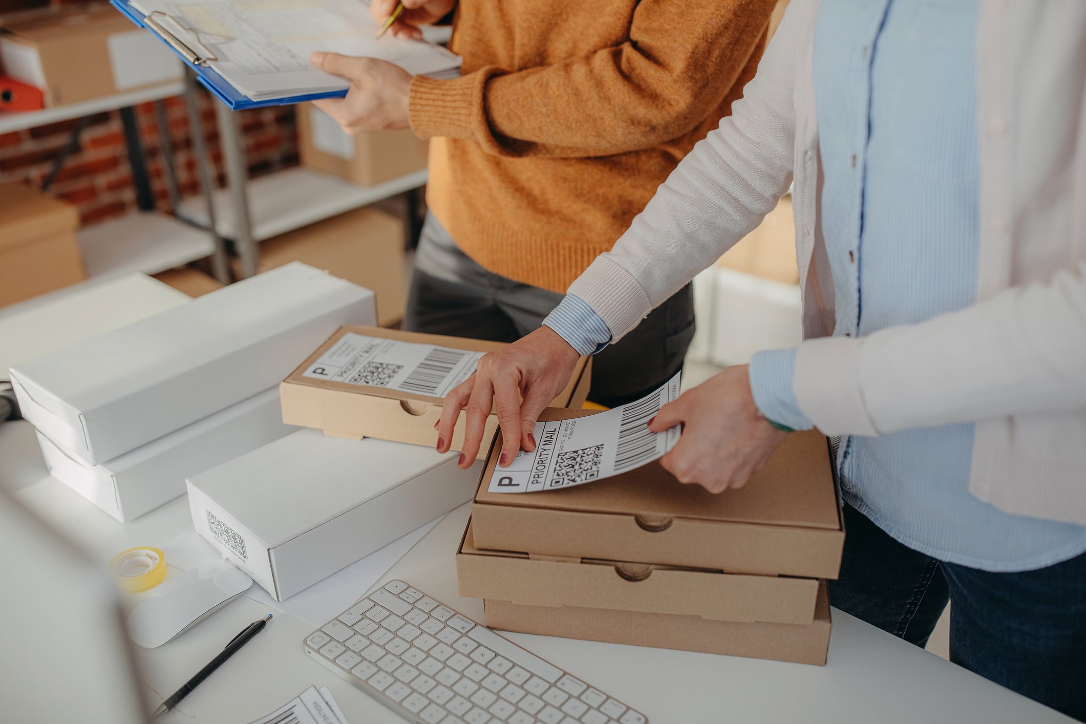 person sticking shipping label to parcel