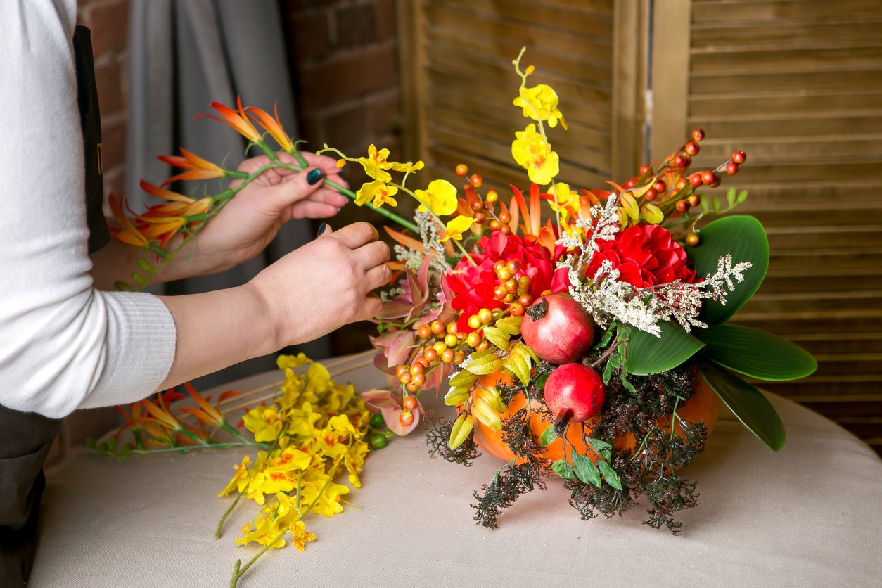 Hand making a autumn-themed table centrepiece