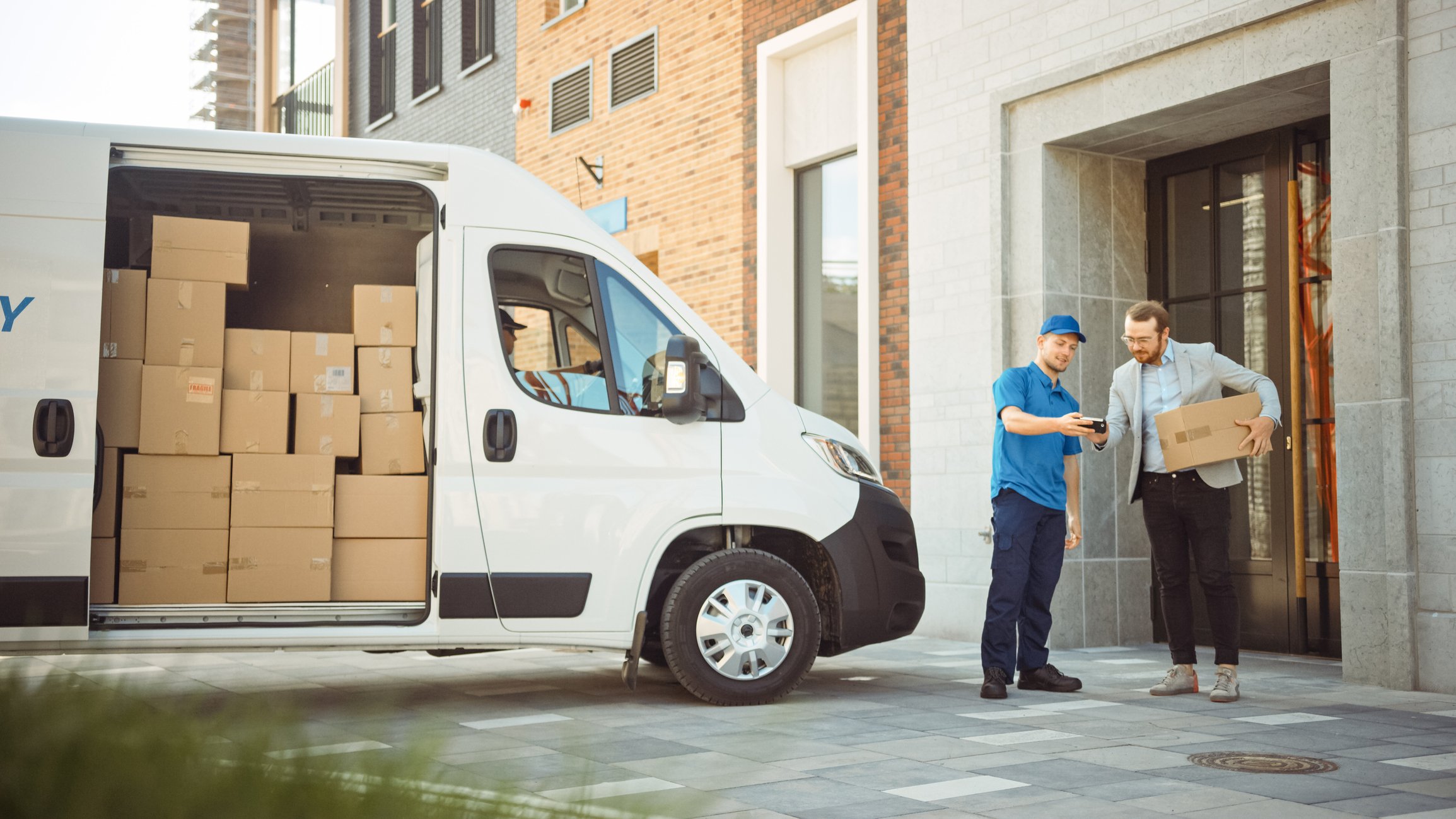 van of parcels with driver getting signature