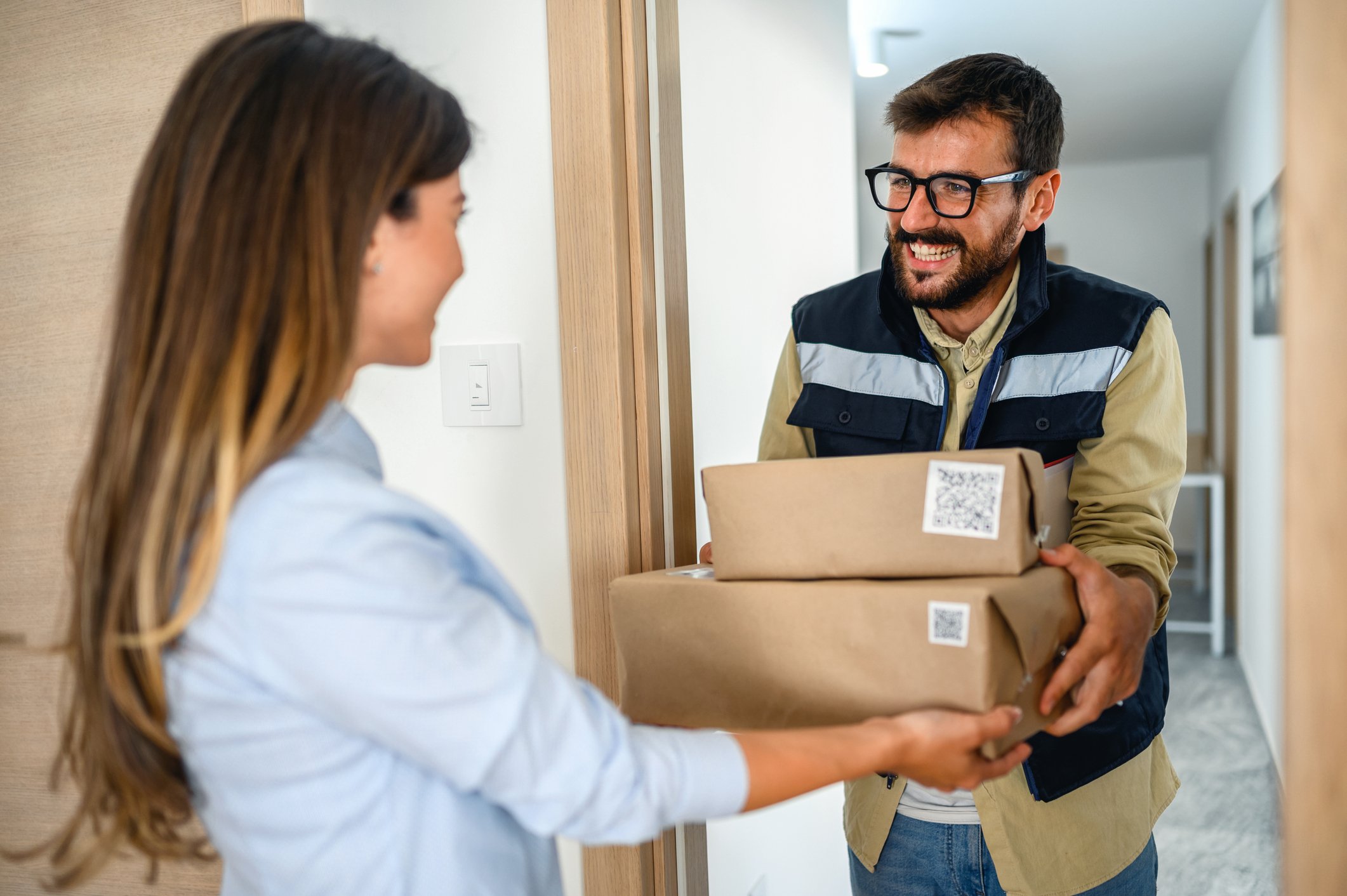 woman handing parcel to delivery man