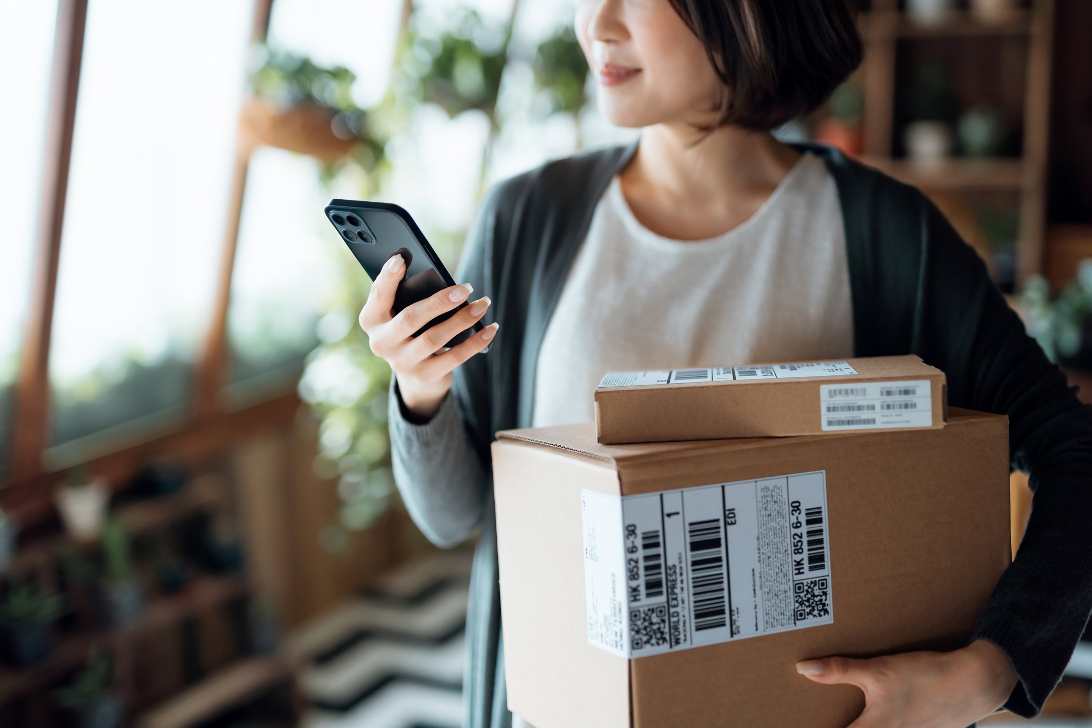 person holding parcels while using phone