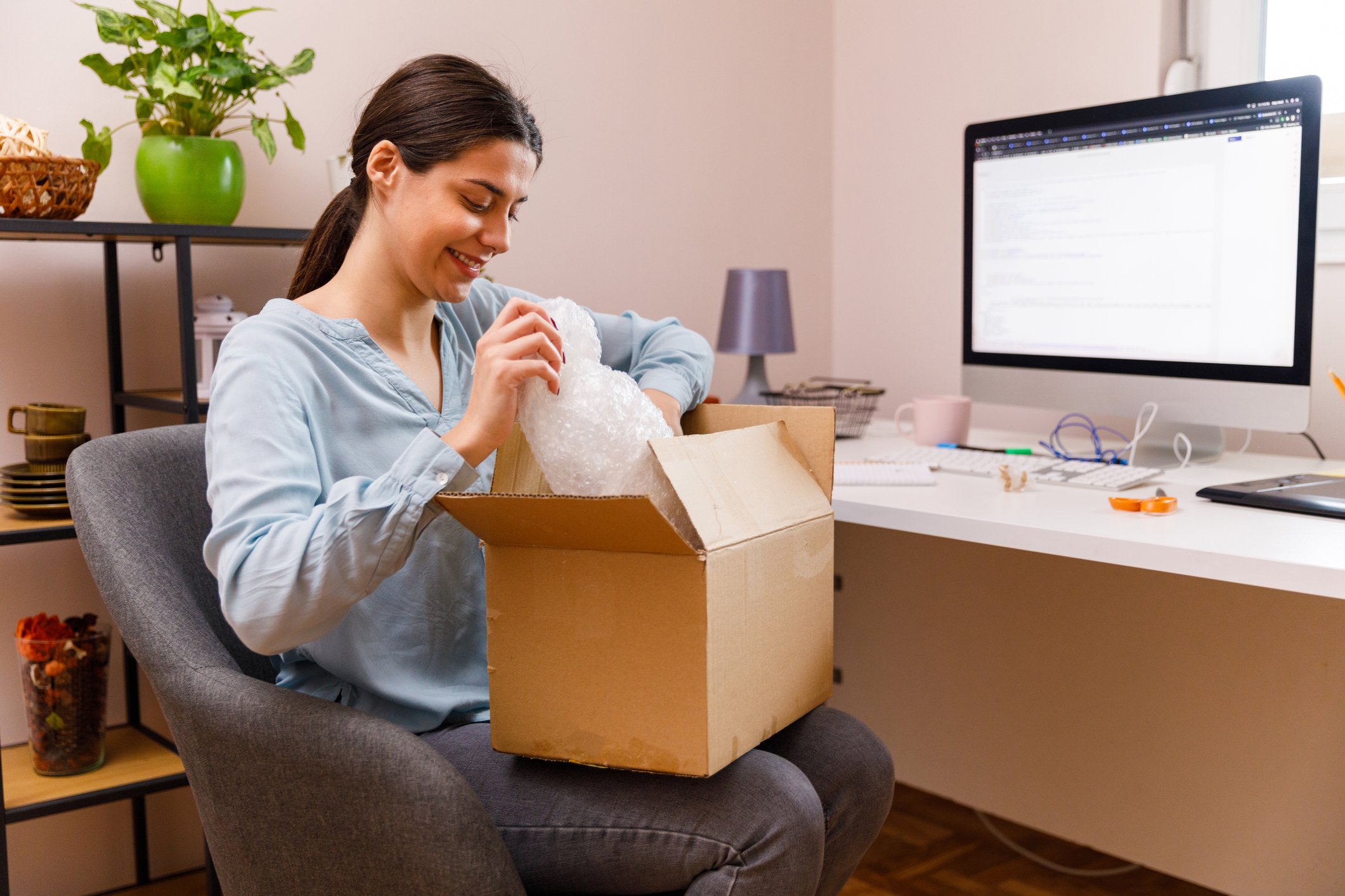 Smiling woman at desk with box on lap