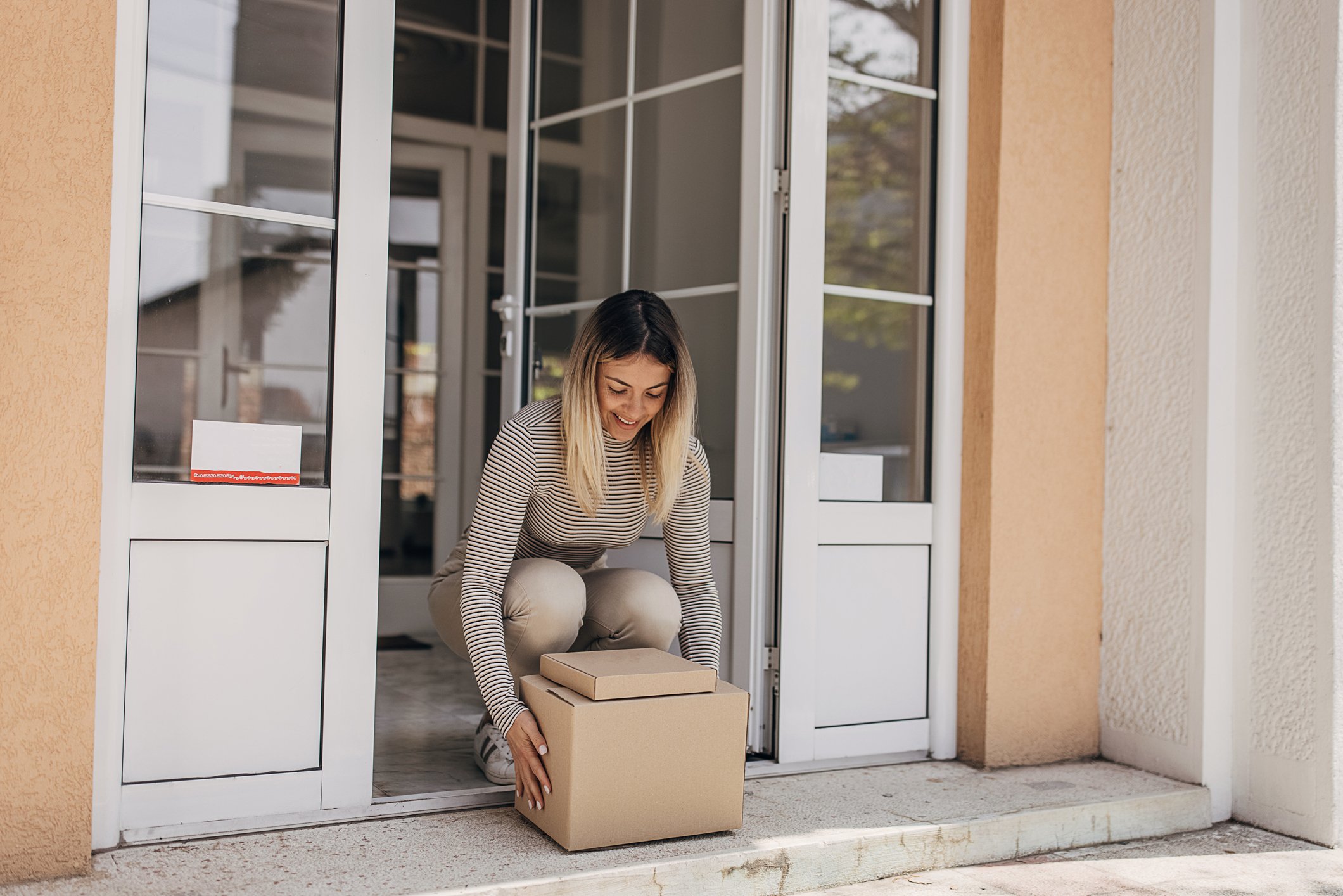 woman picking up a parcel at the front door