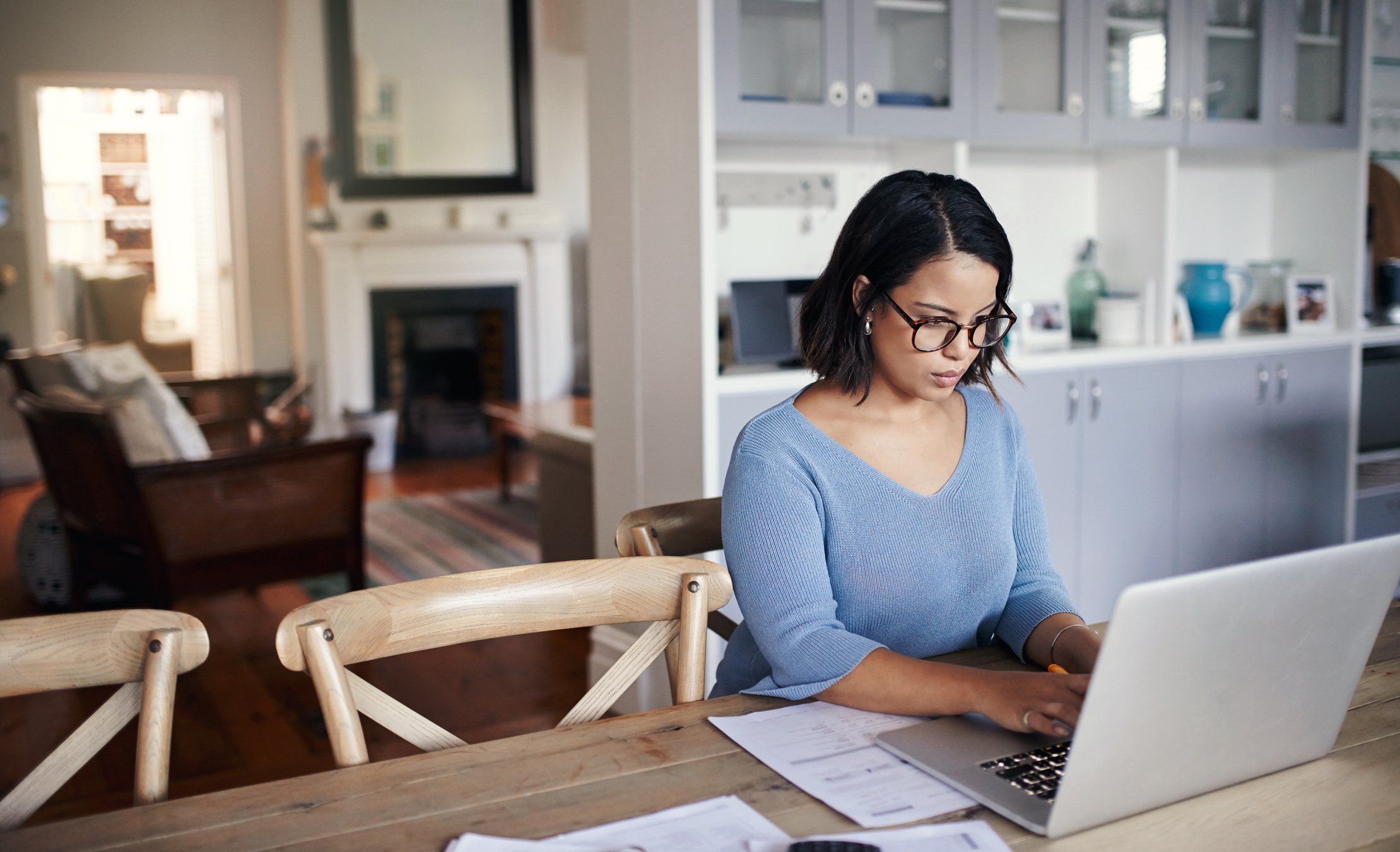 woman using laptop on table at home