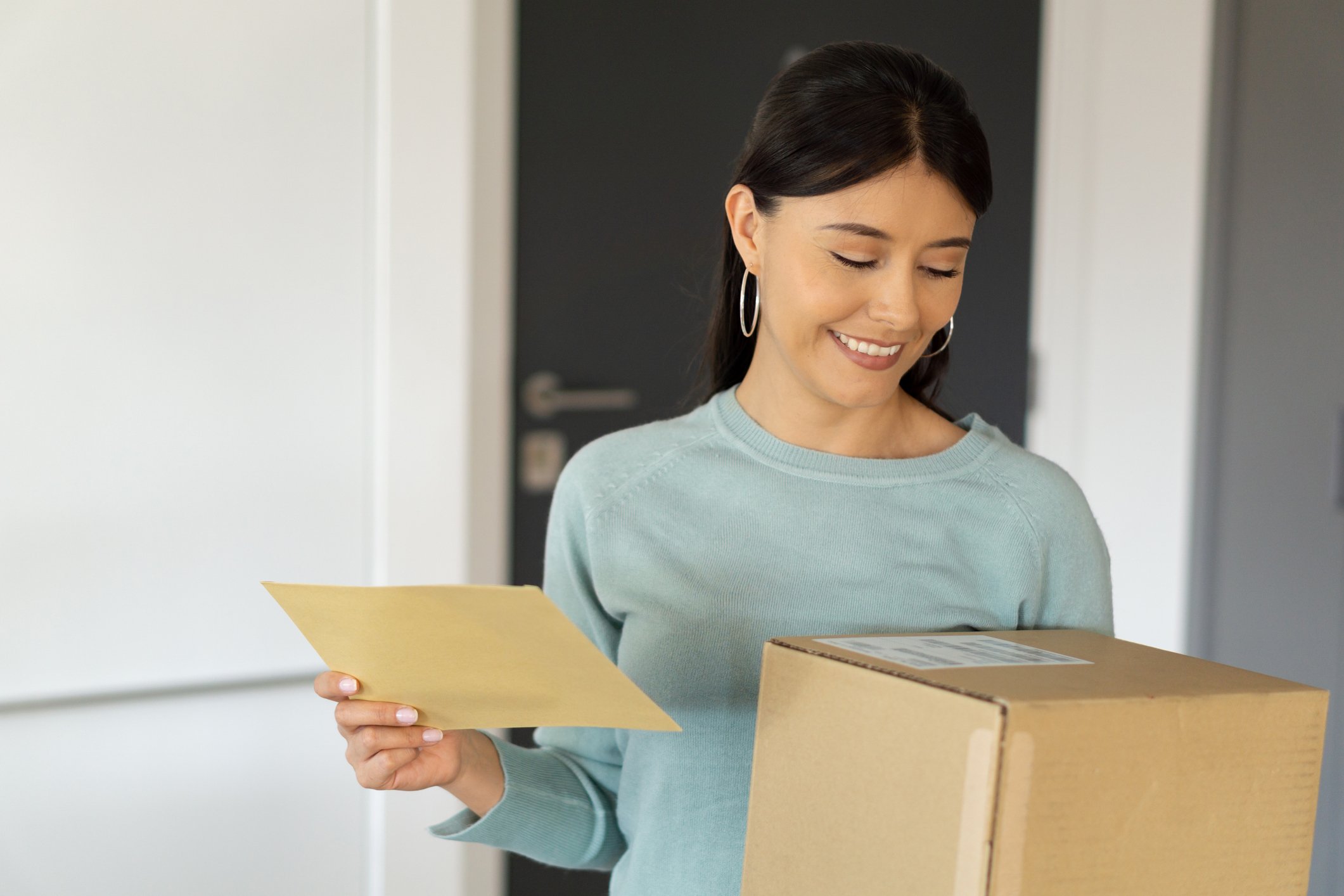 woman-smiling-while-looking-at-parcel