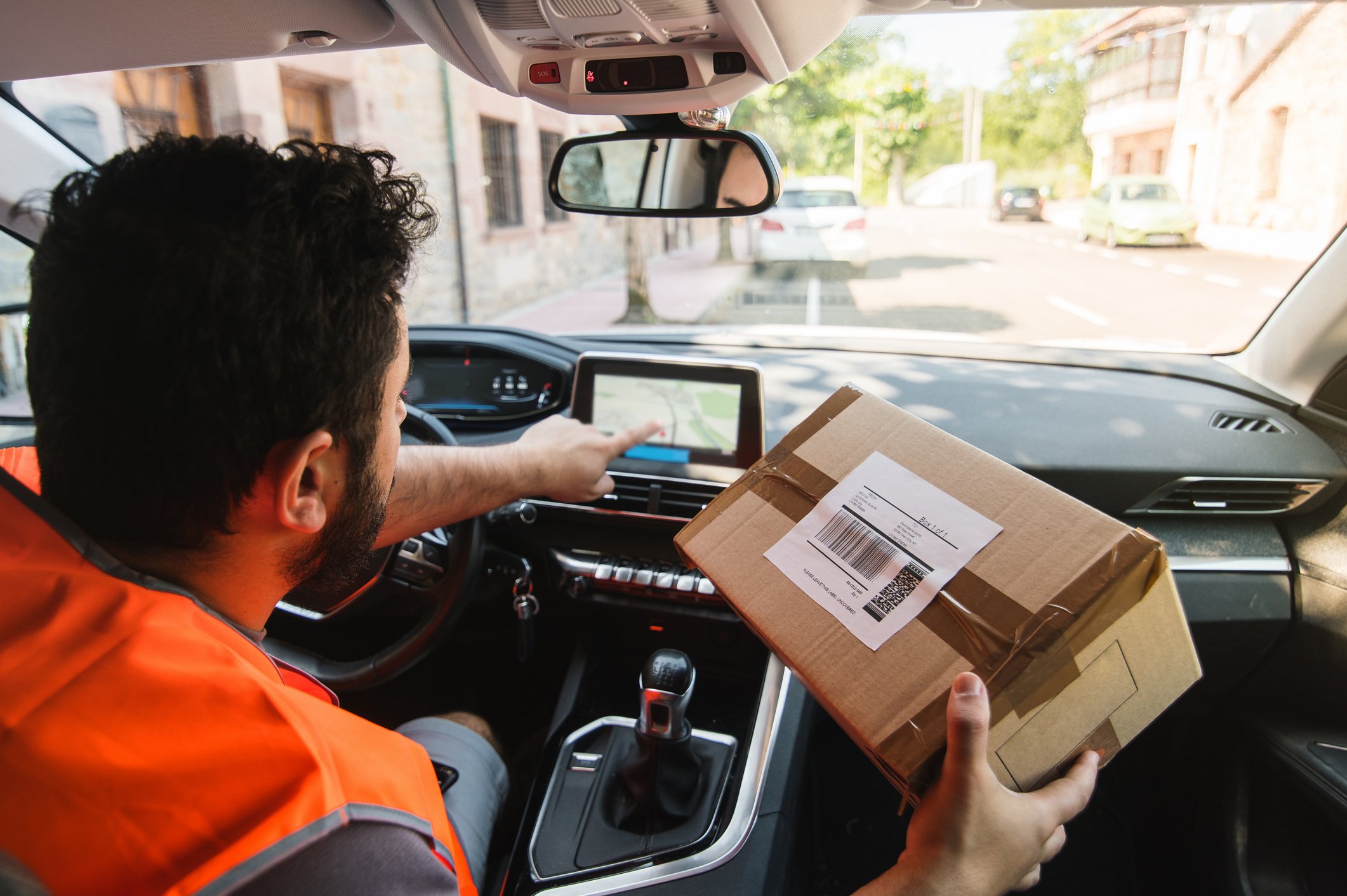 Delivery man in van looking at parcel